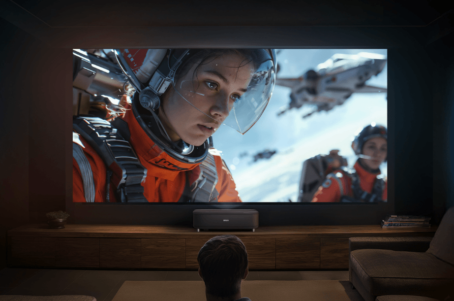 A person watches a sci-fi space movie on a large projector screen with an epson ultra short throw projector in a dark, modern home theater.