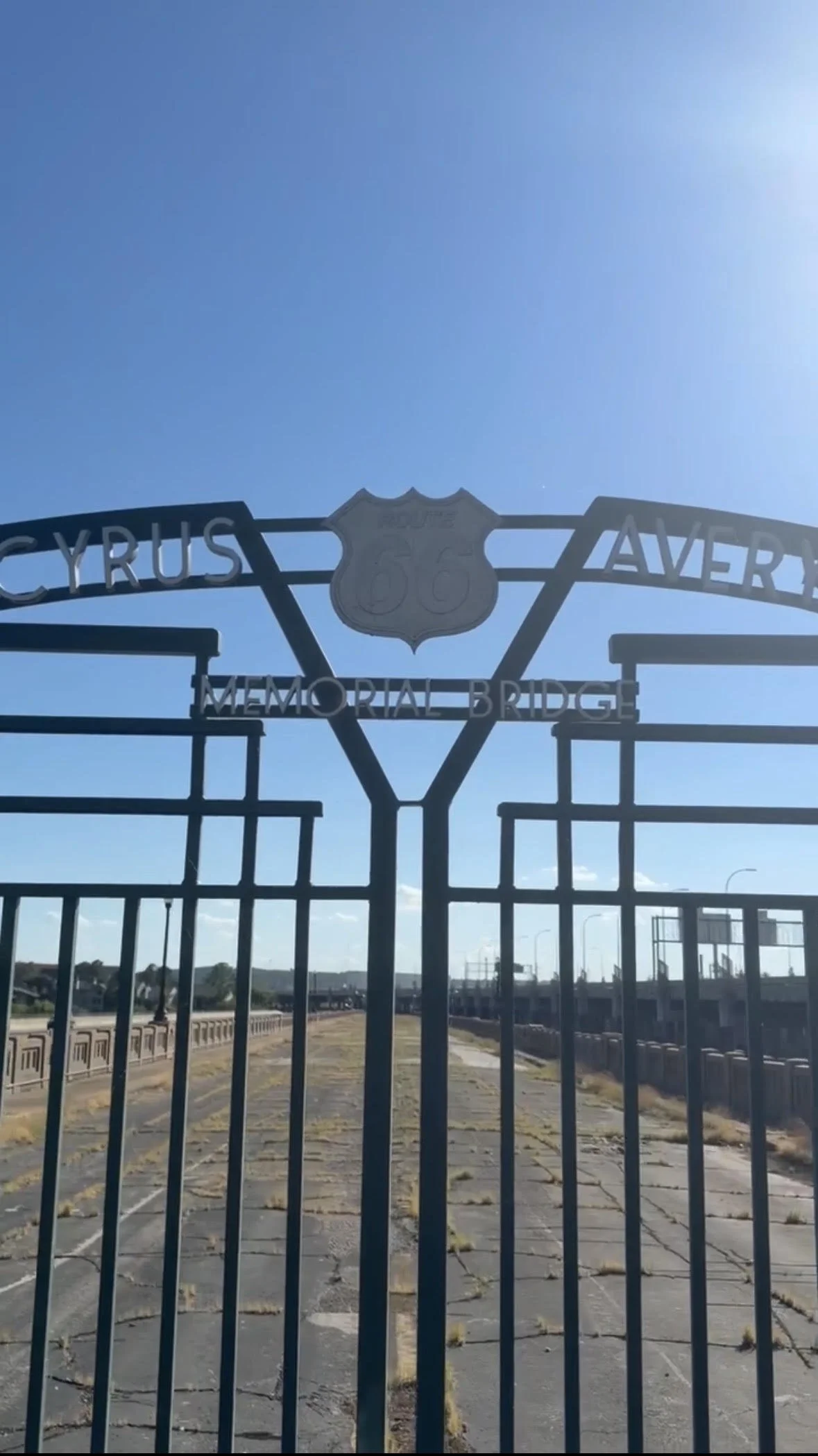 Old metal gate to historic bridge with Cyrus Avery written on top
