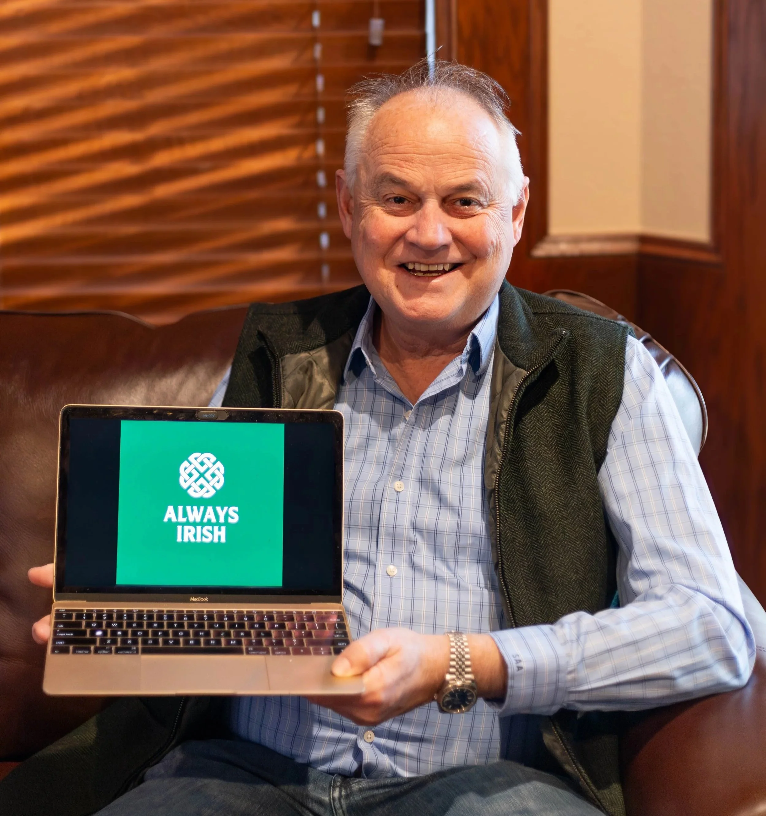 Man holds laptop that says Always Irish