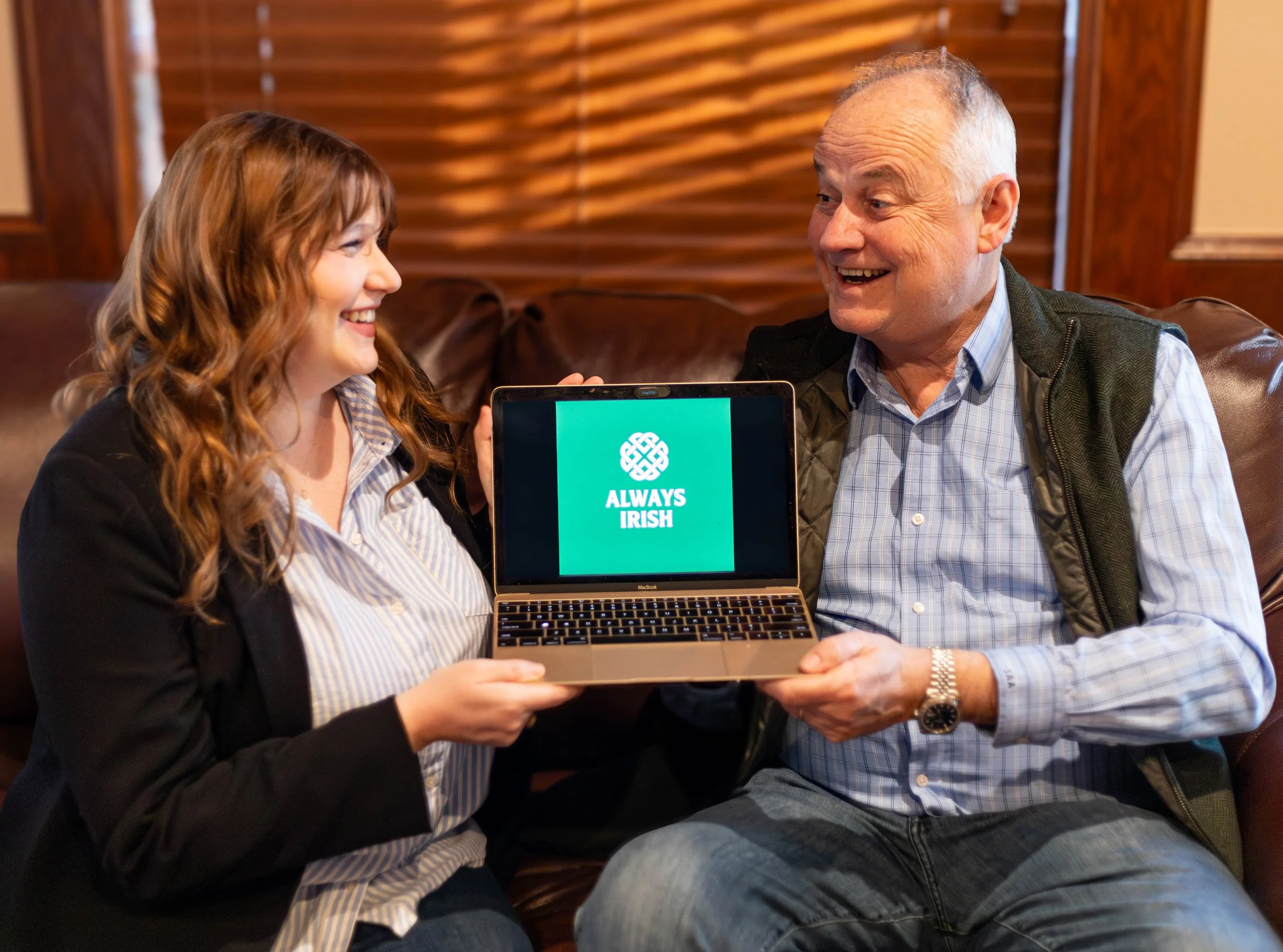Woman and man holding a laptop that says Always Irish