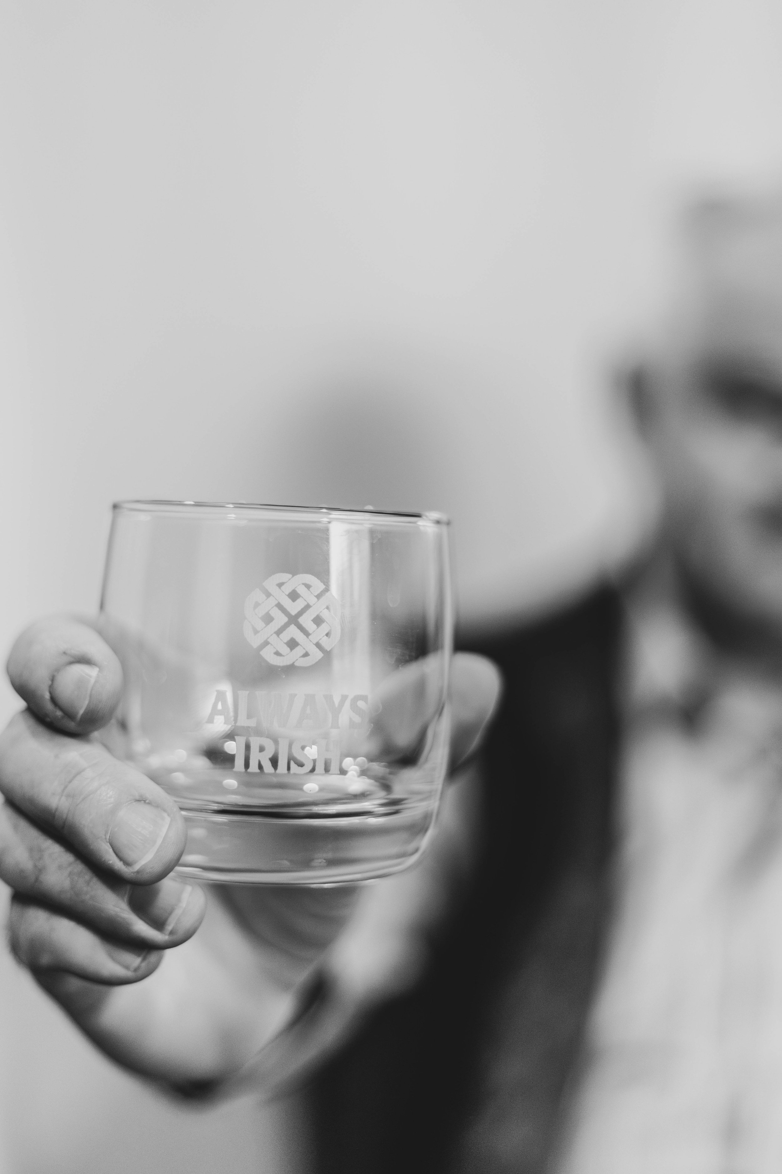 A hand holding a glass that says Always Irish