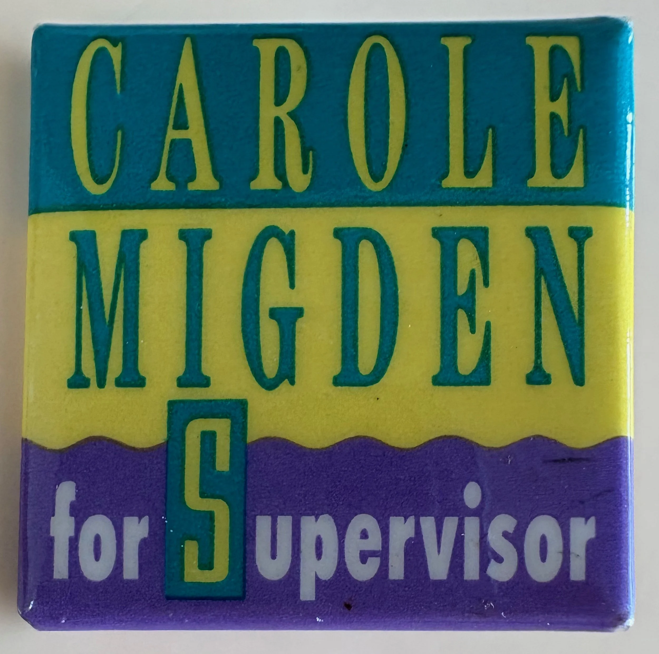 Colorful square sign with the text 'Carole Mideen for Supervisor' in different colors and fonts.