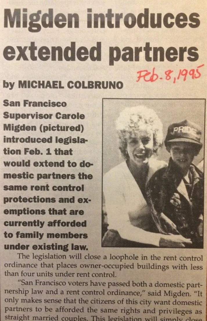 Newspaper clipping with headline 'Migden introduces extended partners,' dated February 8, 1995, featuring a woman with curly hair and a person wearing a hat that says 'PRIDE.'