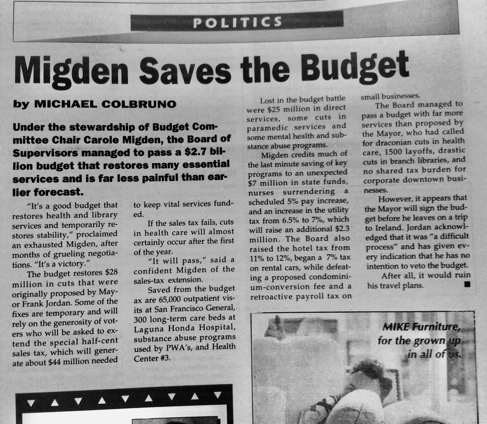 Newspaper article titled 'Migden Saves the Budget' under the Politics section, discussing budget adjustments and their impact on city services, with a photo of a woman with dark hair, glasses, and a jacket, sitting at a desk.