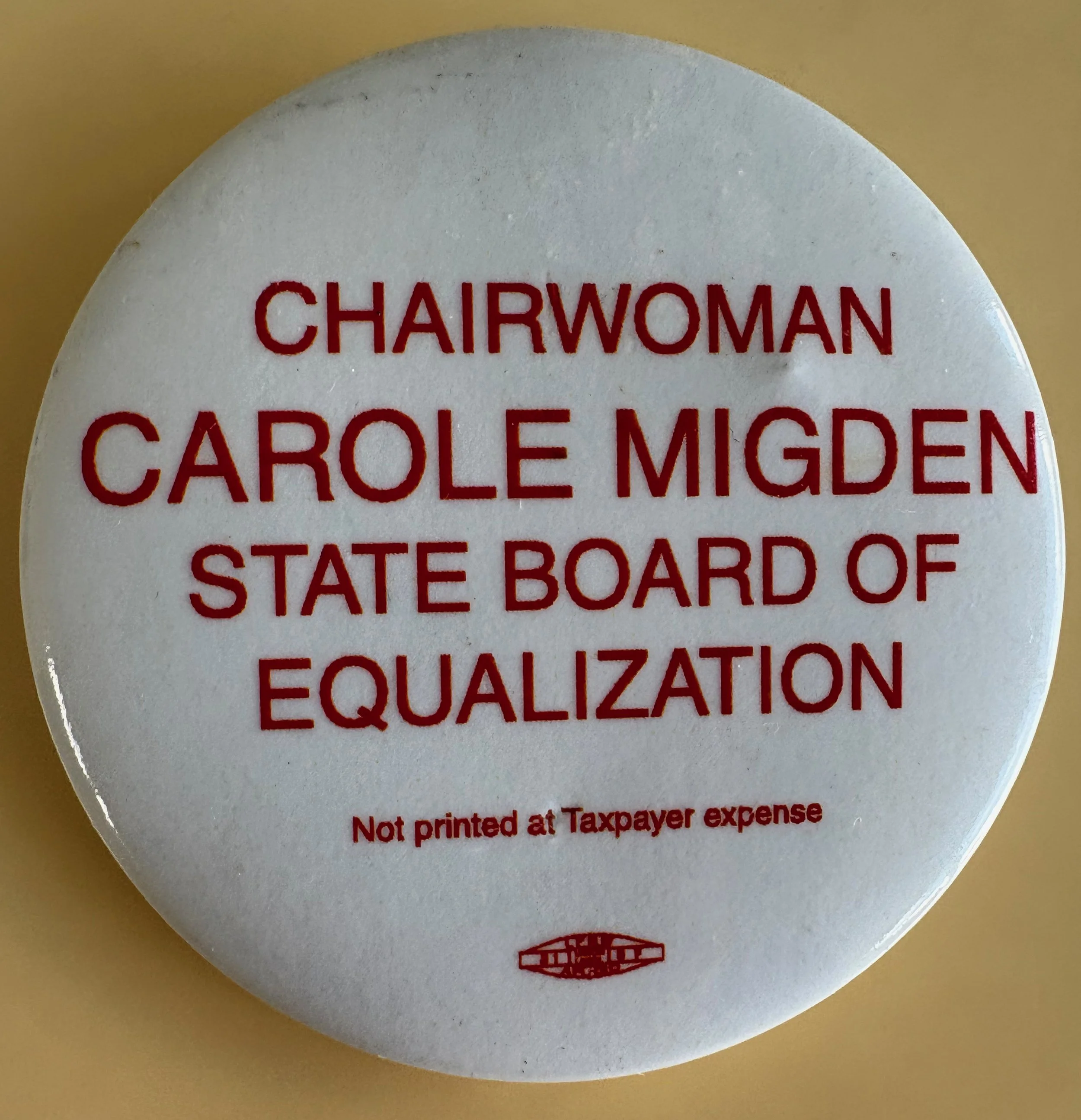 Button with text indicating it is for Carole Migen, Chairwoman of the State Board of Equalization, noting it was not printed at taxpayer's expense.