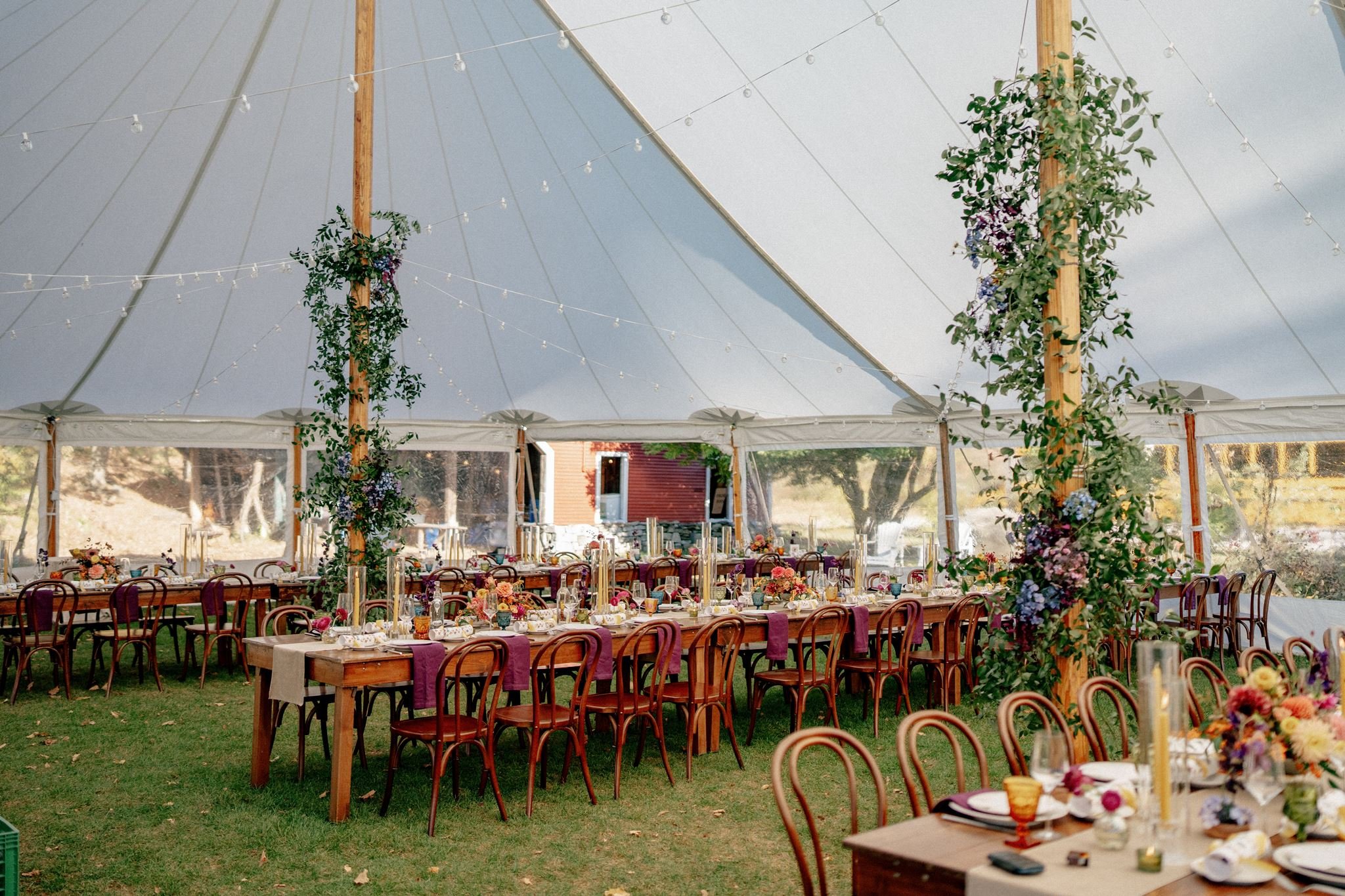beautiful, florals and decor set up inside a large sailcloth tent at a rural central vermont wedding at the tillerman in bristol, vermont