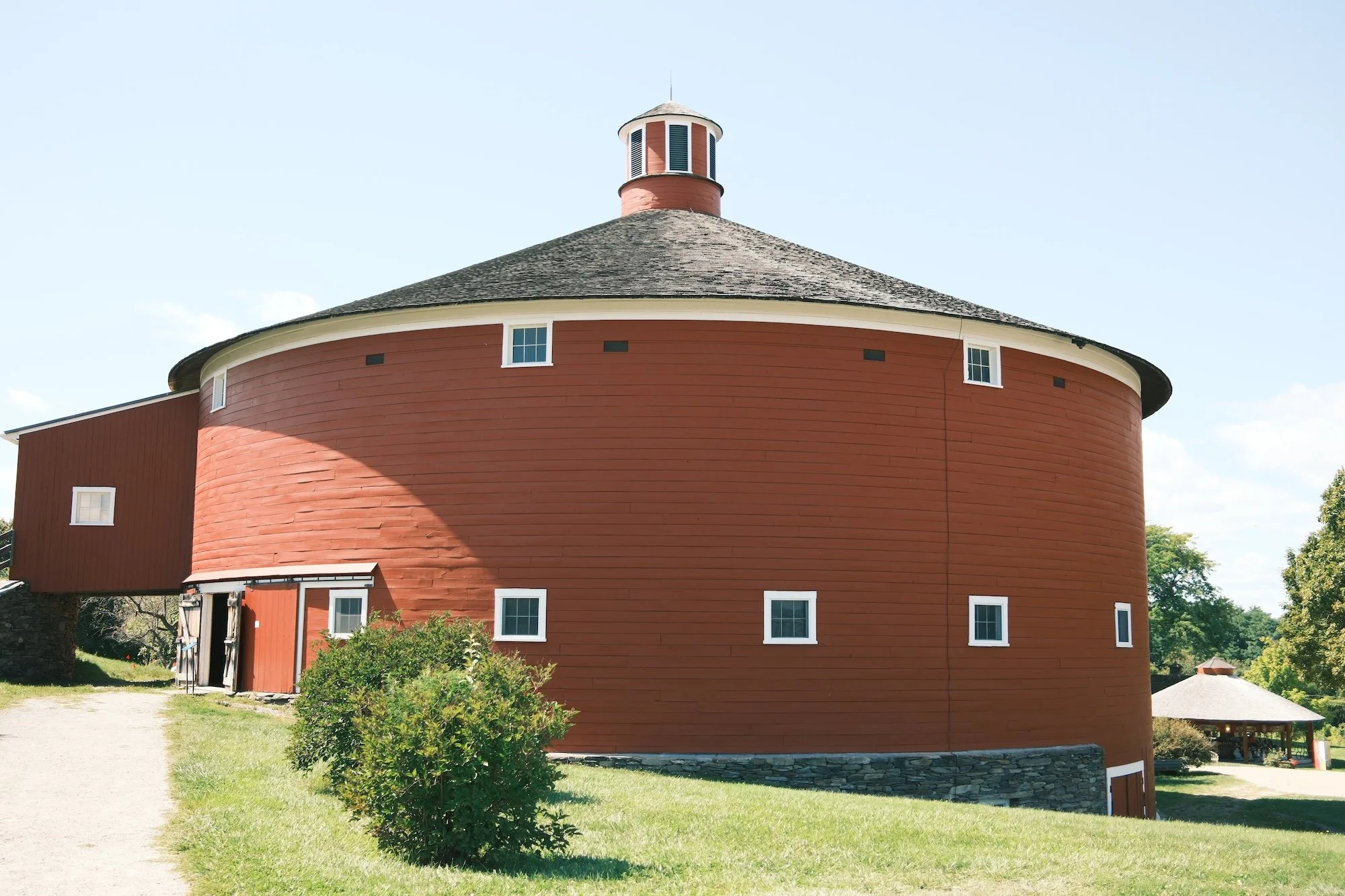 the bright red round barn at shelburne museum in shelburne, vermont