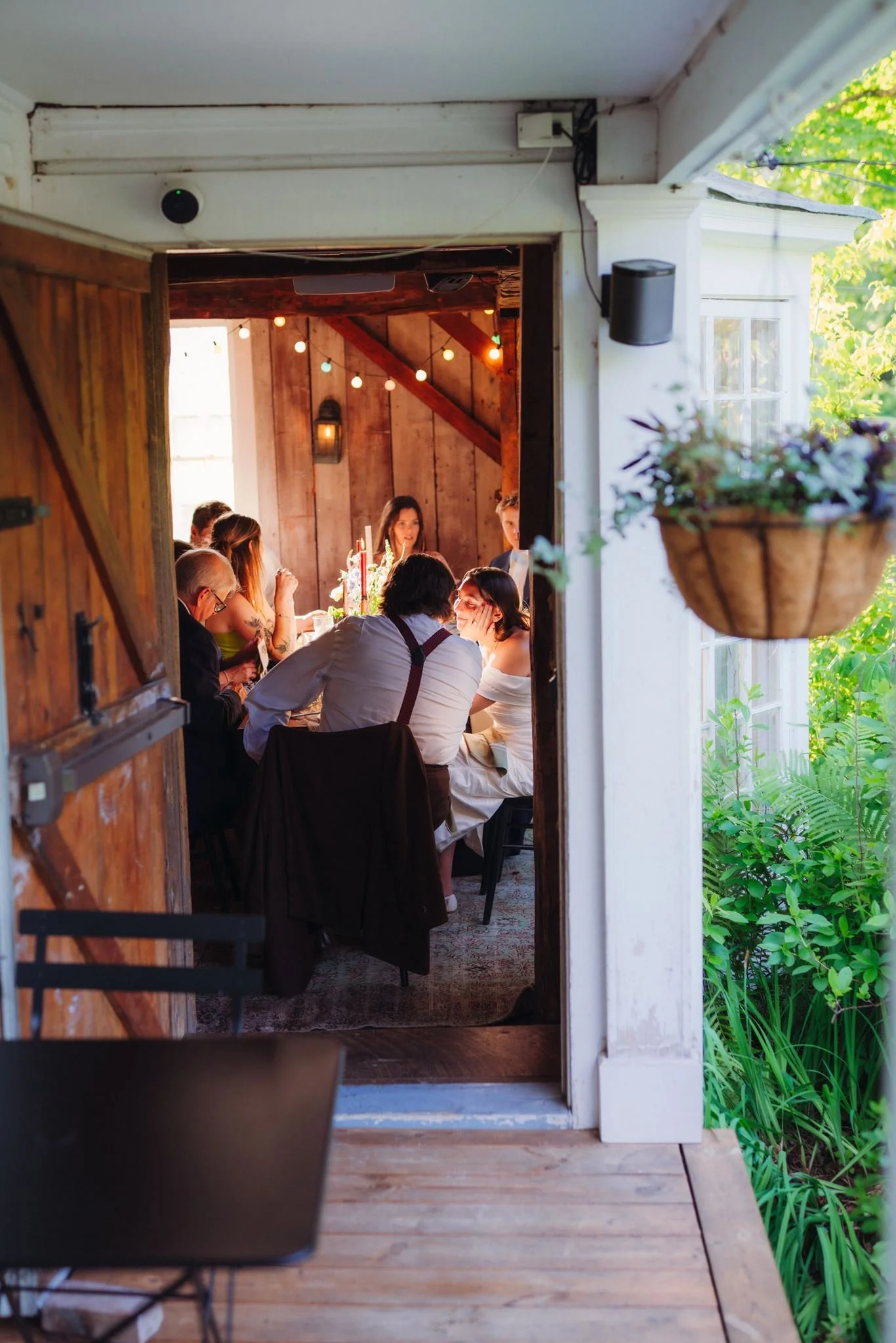 A small wedding eating dinner in the summer kitchen dining room at The Tillerman, a farmhouse inn and restaurant in Bristol, Vermont.