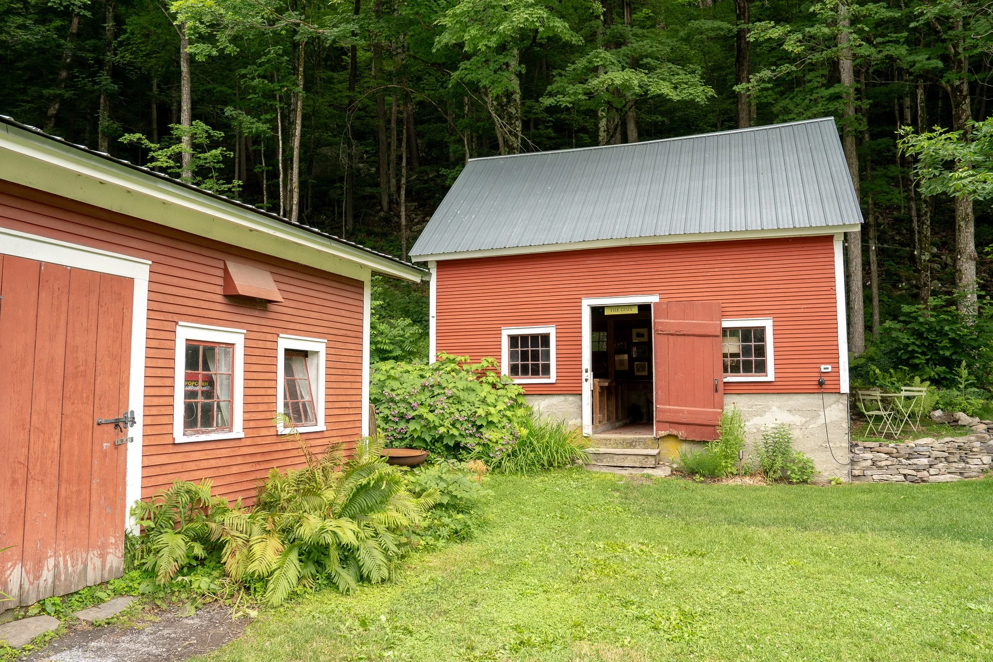 a cottage garden surrounds historic vermont barns at The Tillerman in Central Vermont