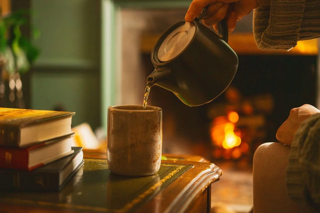 Pouring a cup of tea by the fireplace at The Tillerman Inn.