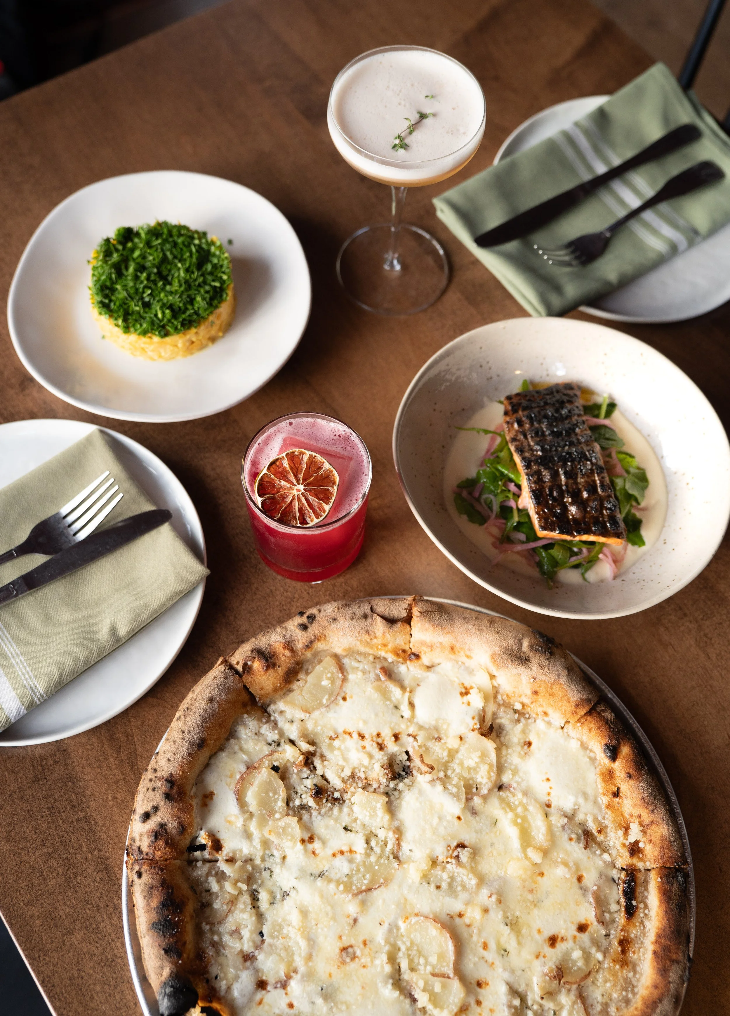 shared plates at the tillerman in bristol, vermont. potato pizza, a winter margarita, beet salad, and arctic char atop a bed of local greens. 