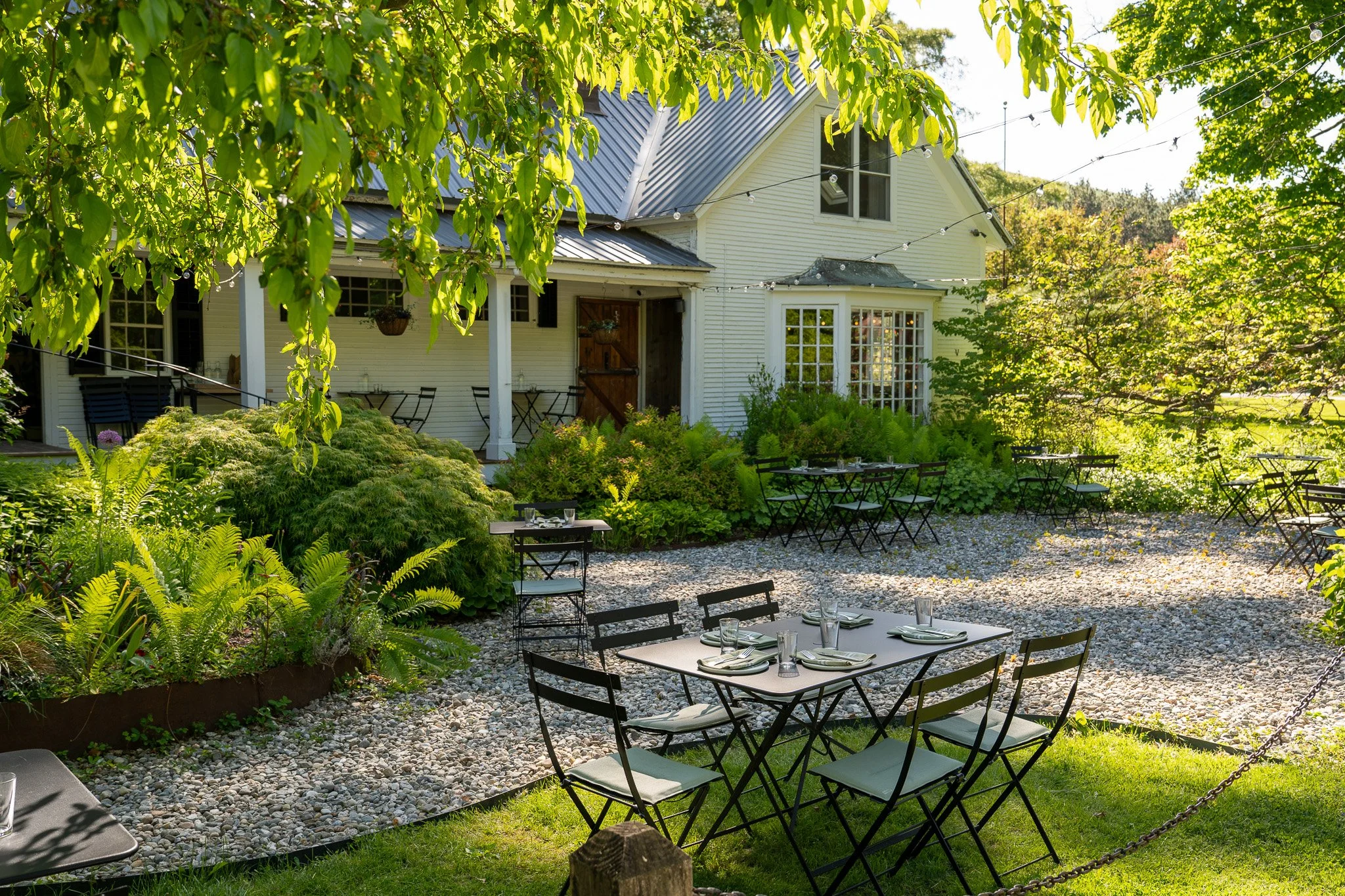 the garden patio at a historic vermont inn and restaurant. enjoy dinner among a beautiful cottage garden with shade trees.
