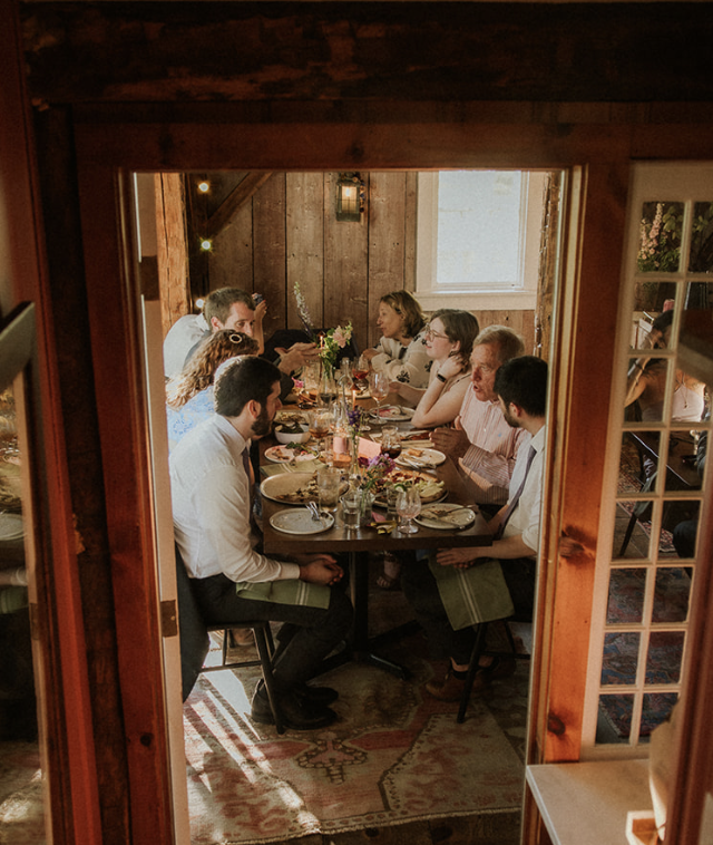 People gathering around a farmhouse table for a small wedding in historic Vermont farmhouse inn and restaurant