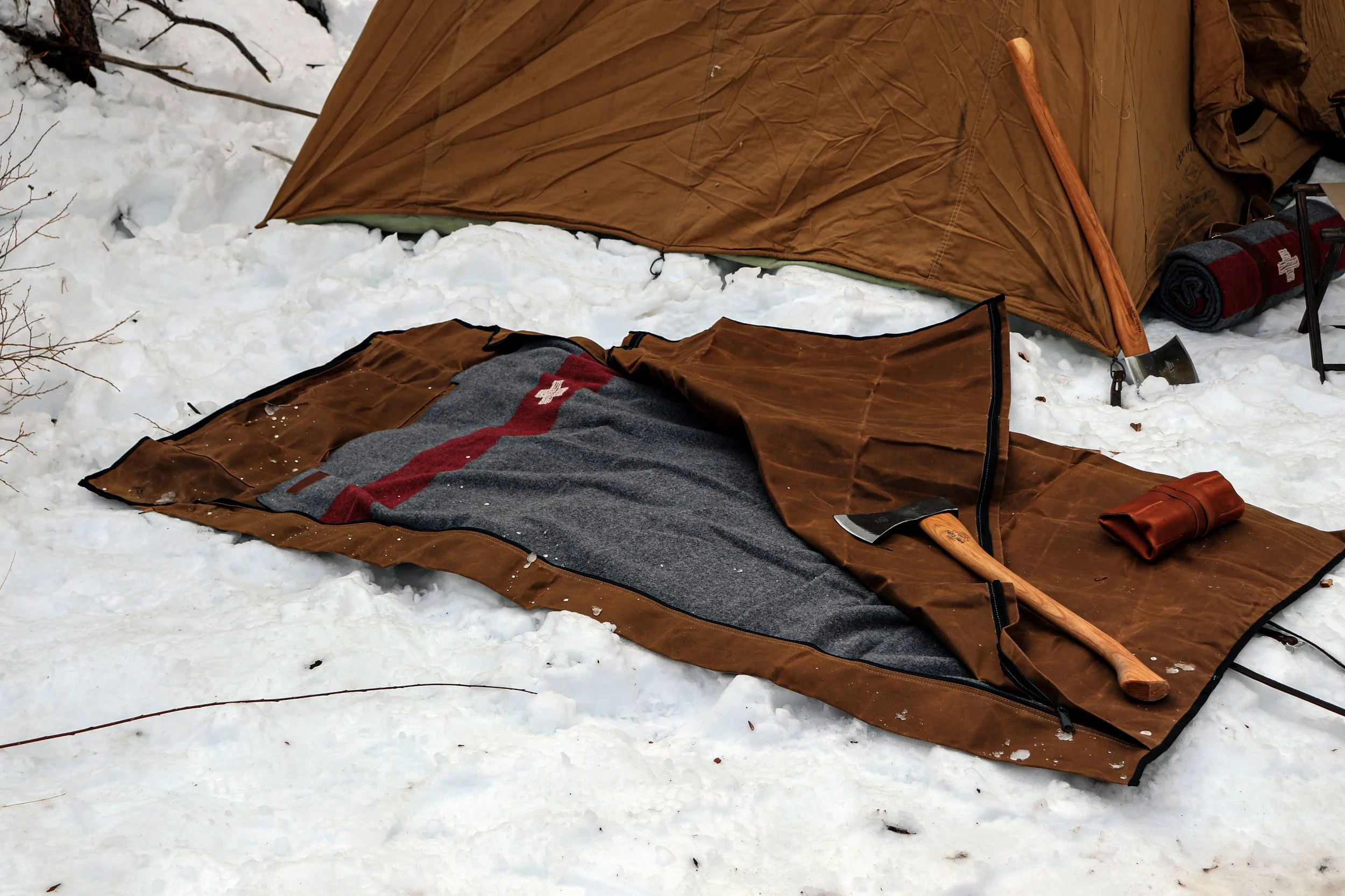 Outdoor sleeping gear set featuring durable canvas bedroll and warm blanket