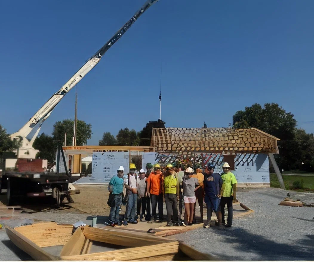 Group of construction workers gathered at a building site with a crane and partially constructed building in the background during daytime.