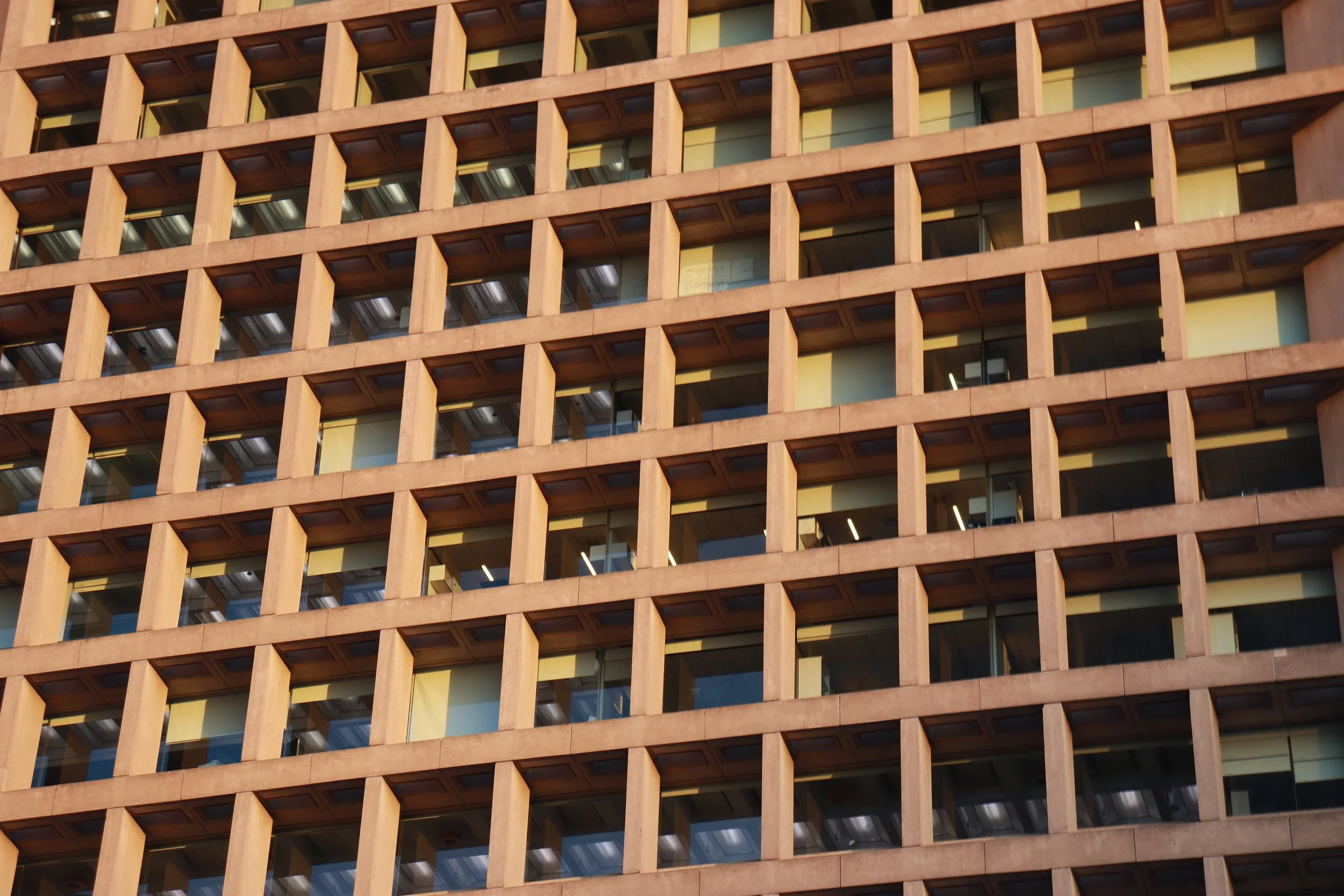Close-up of a building's exterior with a grid of windows and wooden framing.