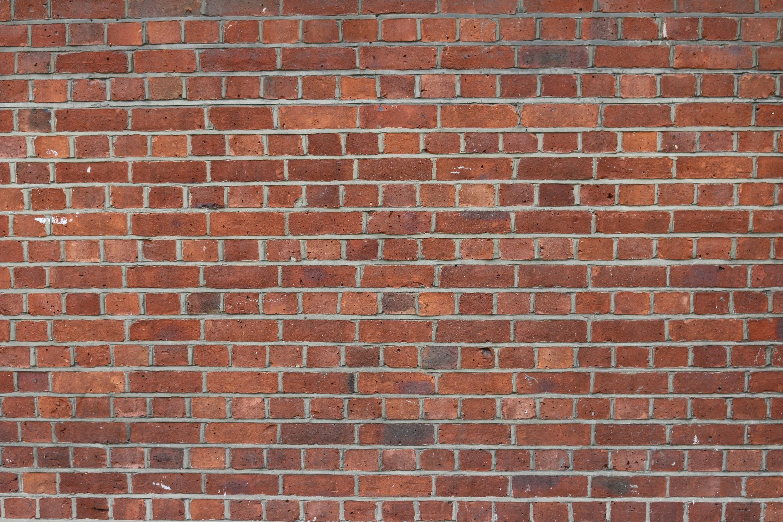 A close-up view of a red brick wall with horizontal mortar lines.
