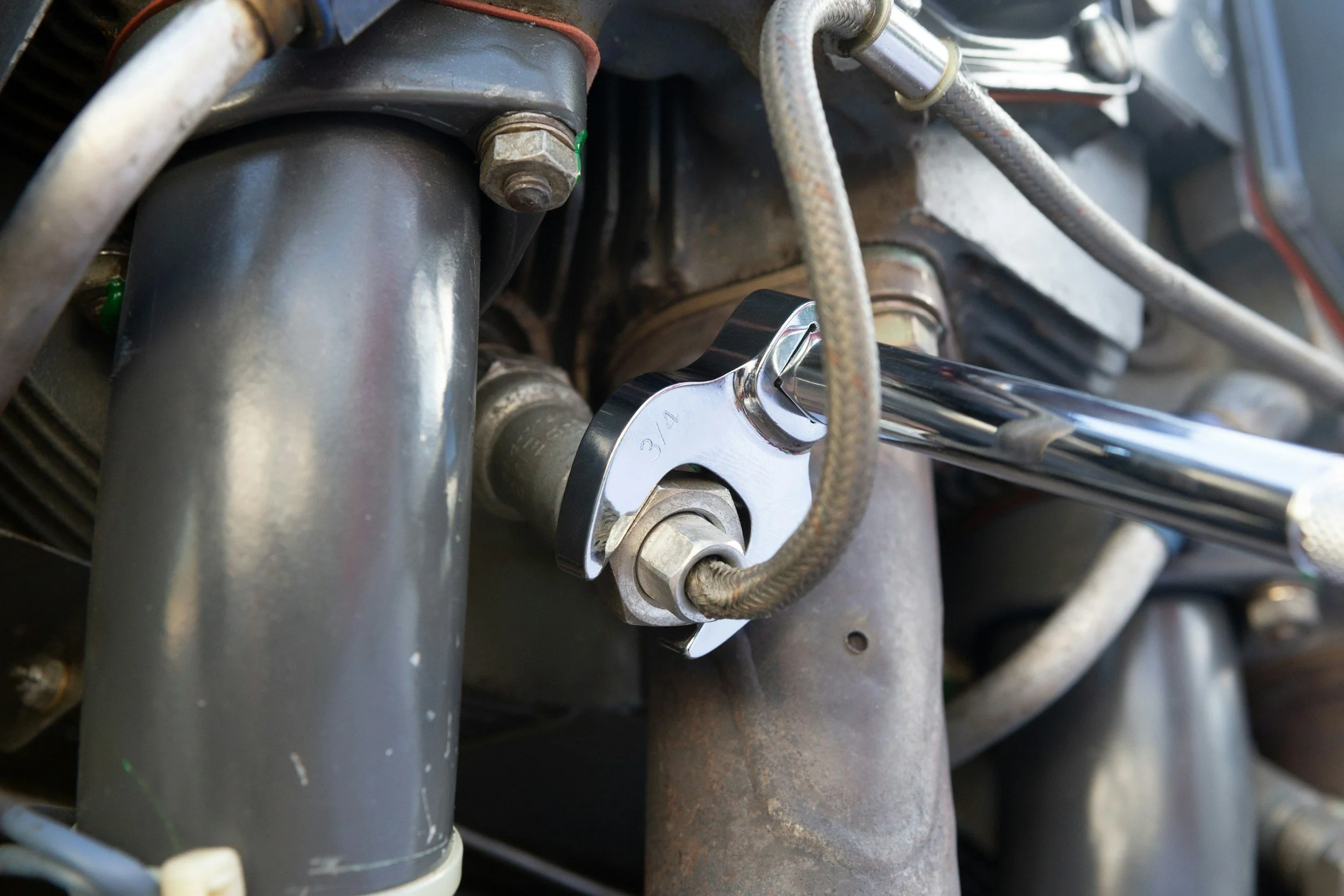 Close-up of a wrench tightening a bolt on a machine component.