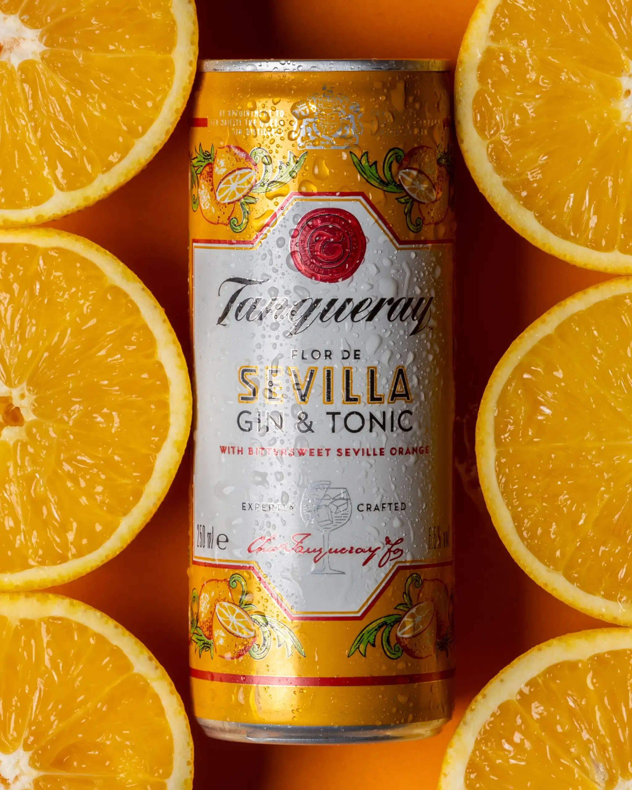 commercial product photography studio image of a can of Taittinger Flor de Sevilla gin and tonic with orange slices surrounding it.