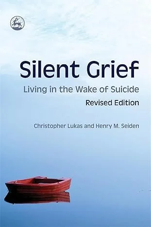 Book cover titled 'Silent Grief: Living in the Wake of Suicide, Revised Edition' by Christopher Lukas and Henry M. Seiden, featuring a red boat on calm water with a cloudy sky in the background.