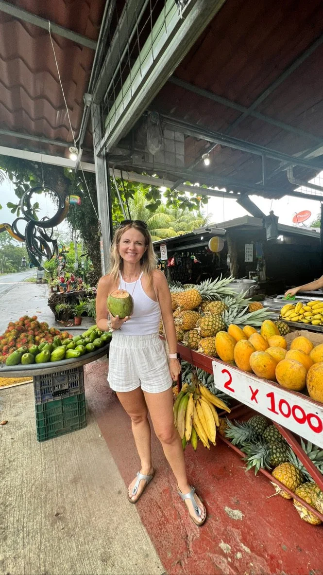 Raechelle holding a coconut at a small local market in Costa Rica.