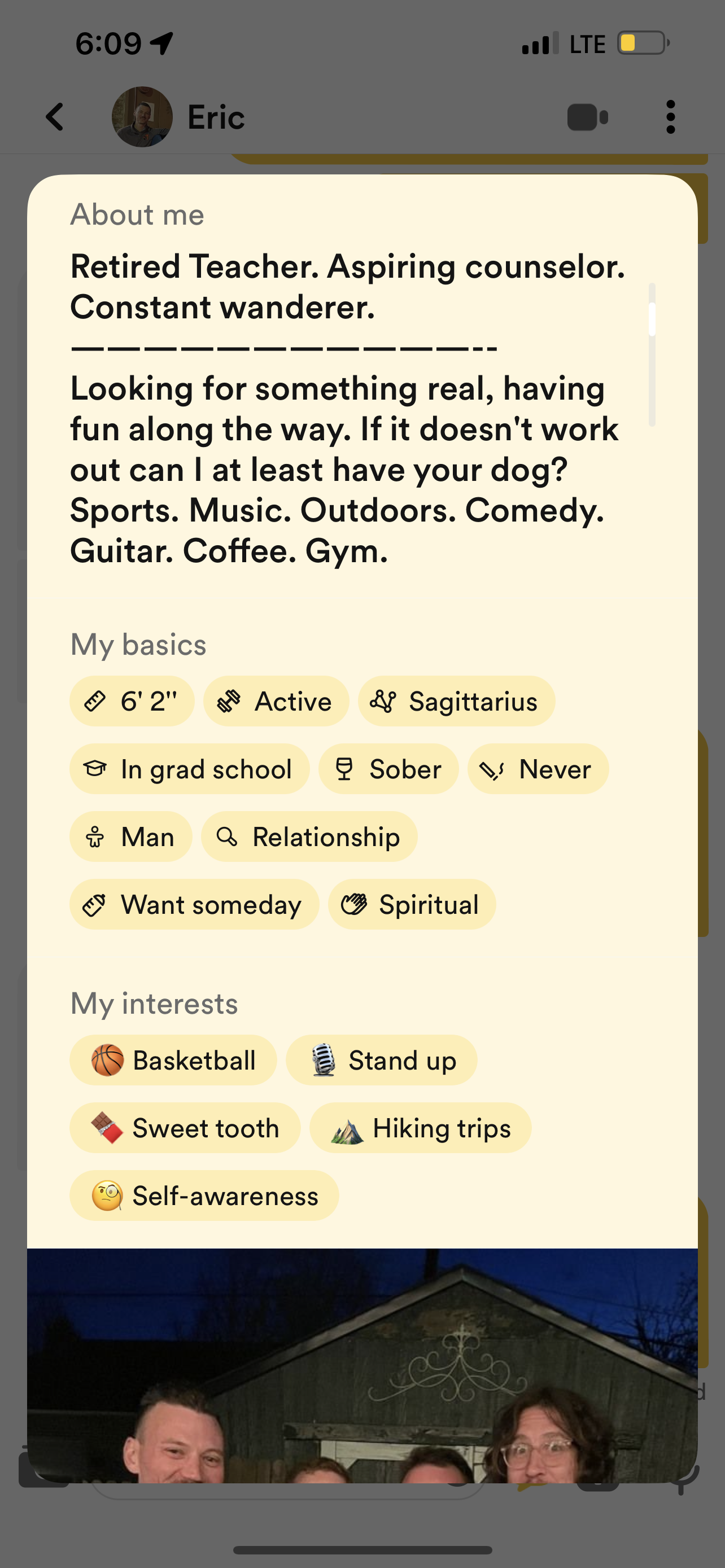 Profile description and interests of a man named Eric, who is a retired teacher, aspiring counselor, and constant wanderer. The profile includes details about his height, zodiac sign, education, sobriety, relationship status, and personal goals. His interests and hobbies are also listed, such as basketball, stand-up comedy, sweet tooth, hiking trips, and self-awareness. The image is part of a social media profile or dating app profile with a photo of Eric and some of his friends.