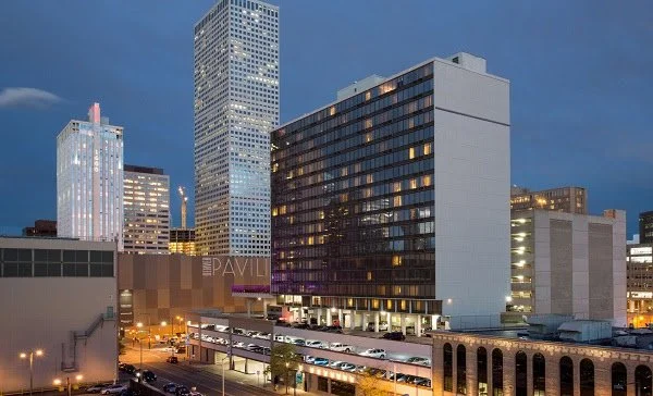 Night view of downtown cityscape with tall modern buildings and parking garage.