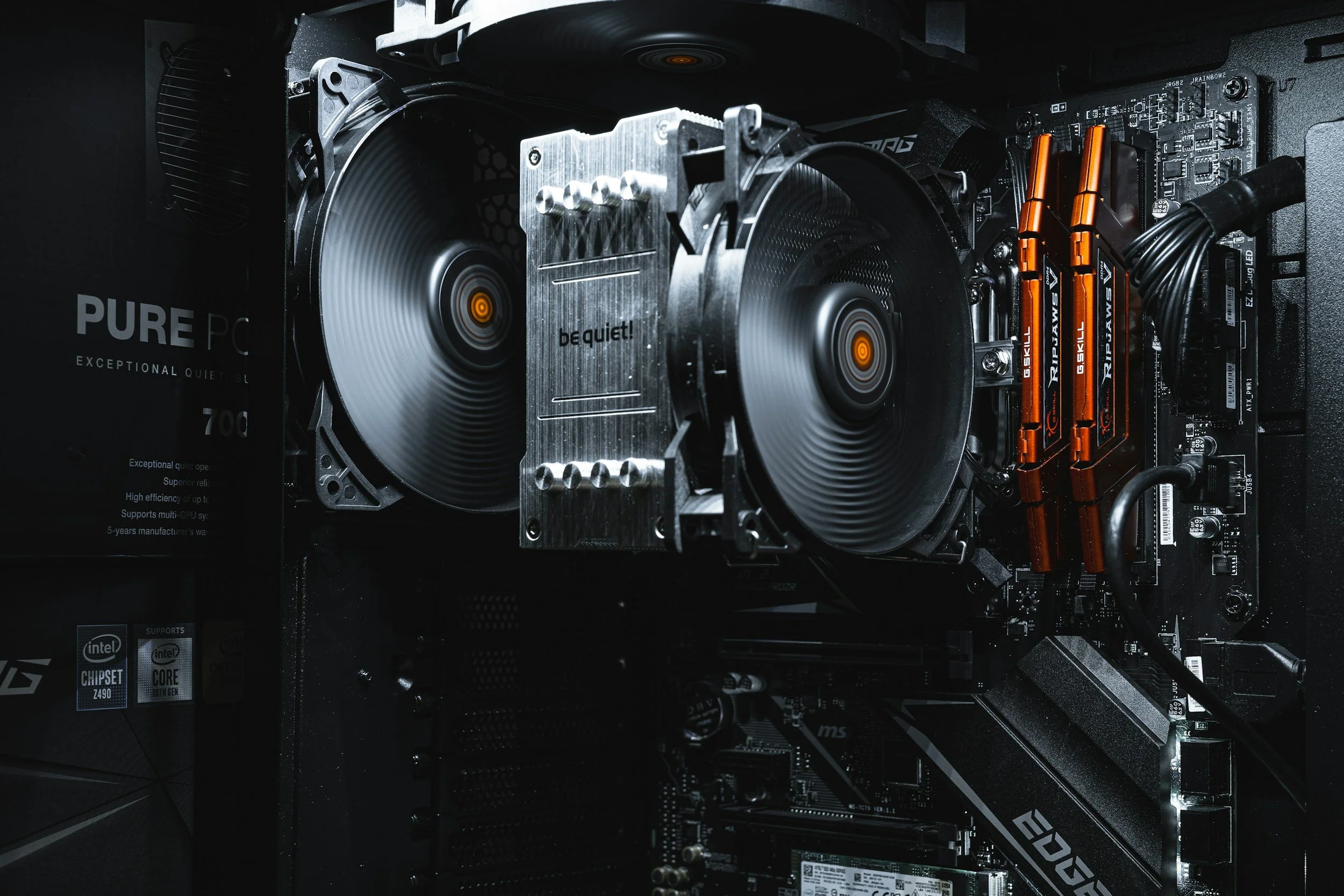 Close-up of a computer's interior showing a large cooling fan, DDR4 RAM modules, and a motherboard.