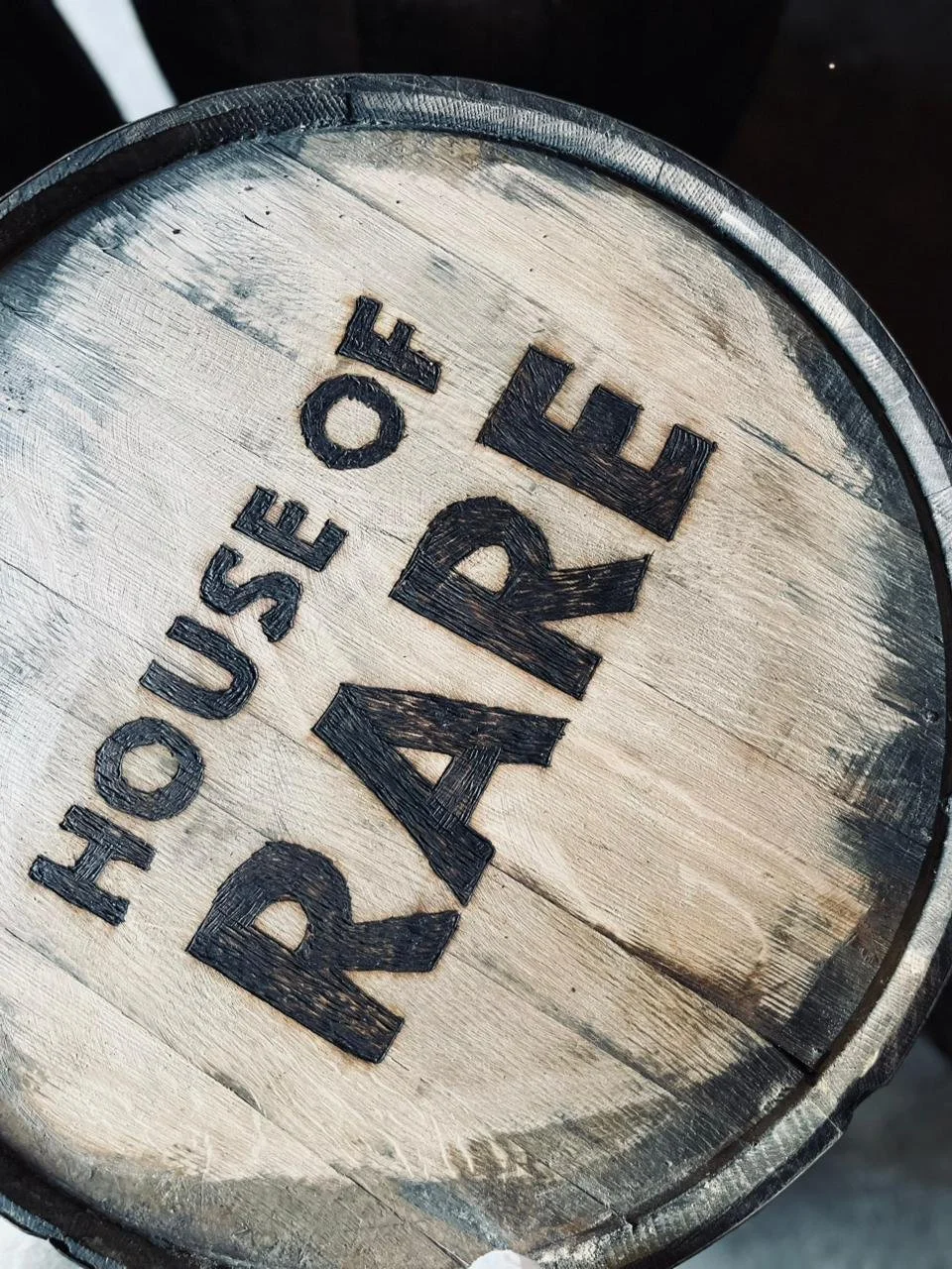 Close-up of a wooden whiskey barrel with the words 'Trousse' and 'R.A.' burned into the wood.