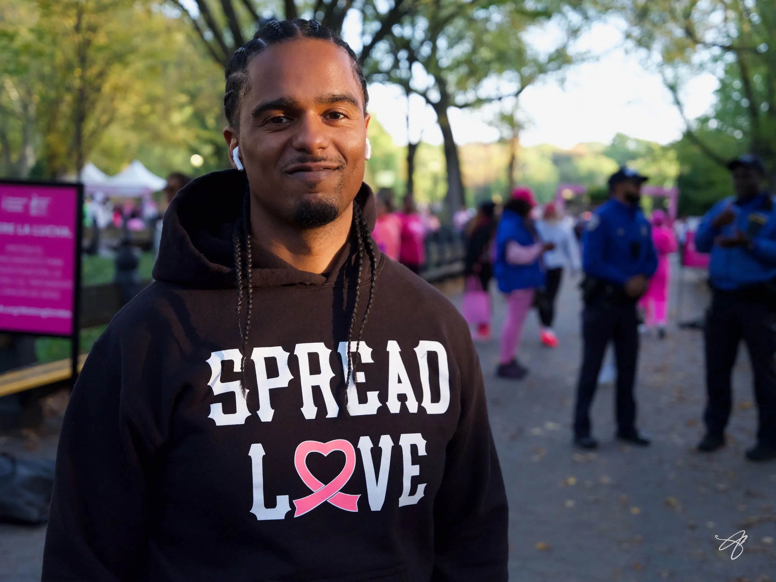 Man wearing a black hoodie with 'SPREAD LOVE' written on it, at the Making Strides Breast Walk event in Central Park, Manhattan, NYC