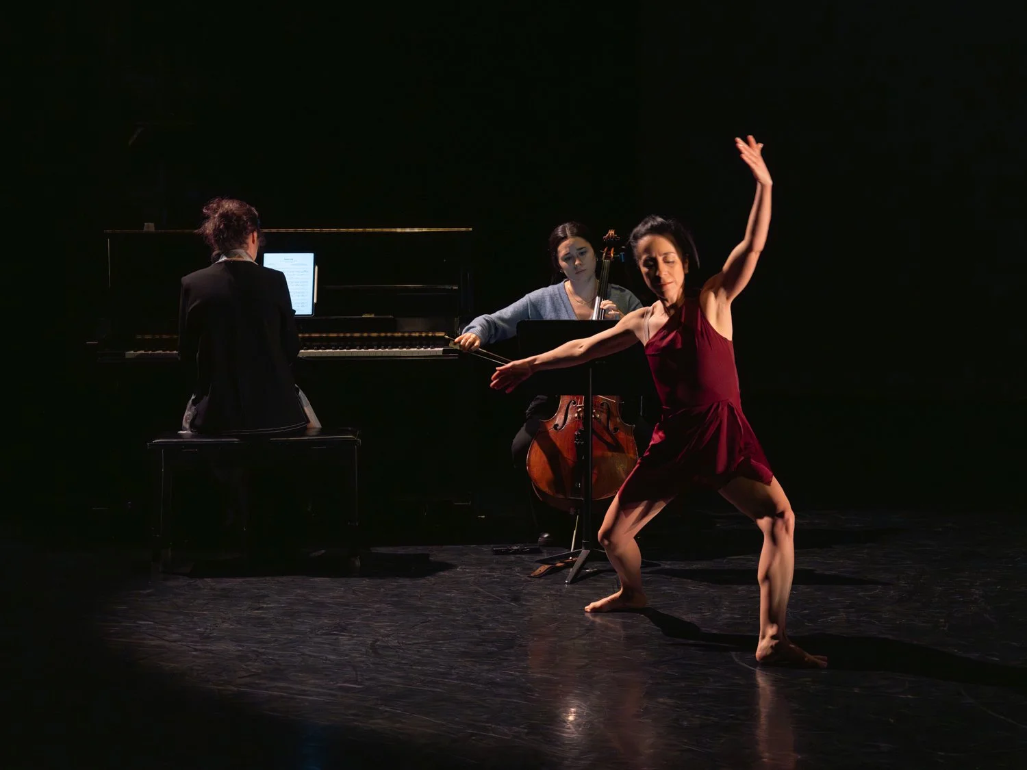 Born Dancing performance, a dancer performing a contemporary dance piece in front of a live piano and cello performance on stage.