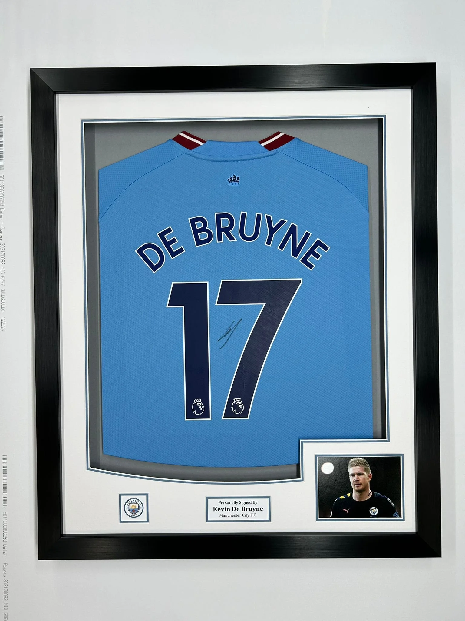 Framed Manchester City jersey signed by Kevin De Bruyne with his signature and photo in the bottom right corner.