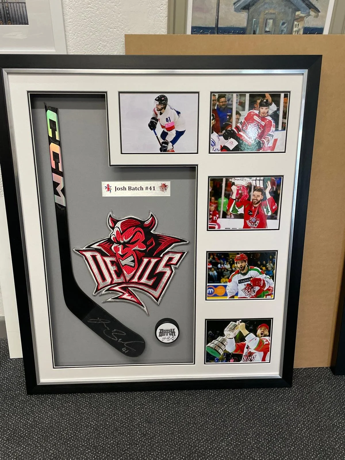 Framed collage of hockey memorabilia and photos of a player with the number 41, including a team logo, autographed puck, and various action and celebration shots of a hockey player in a red and white jersey.