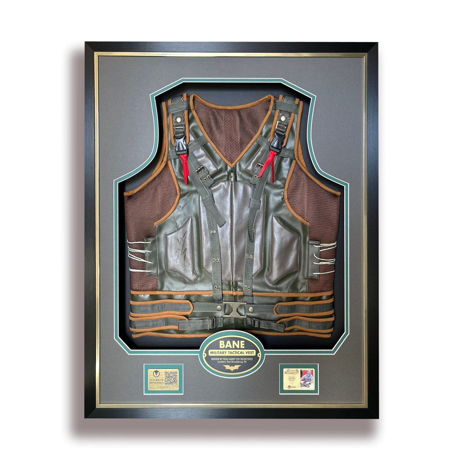 Framed memorabilia display of a military tactical vest labeled 'BANE' with signatures and plaques.