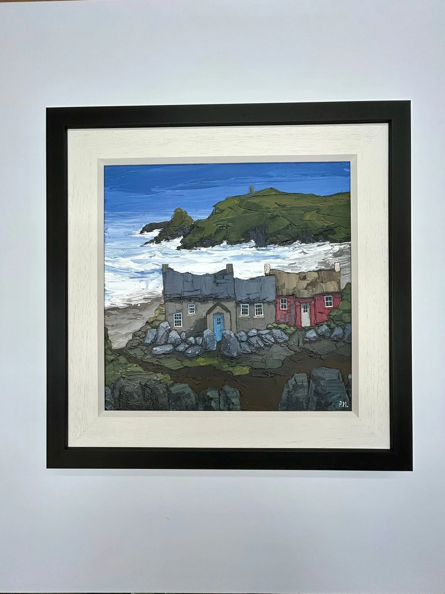 Painting of a coastal scene featuring a rocky shoreline with waves, green hills, and a group of houses with gray and red roofs.