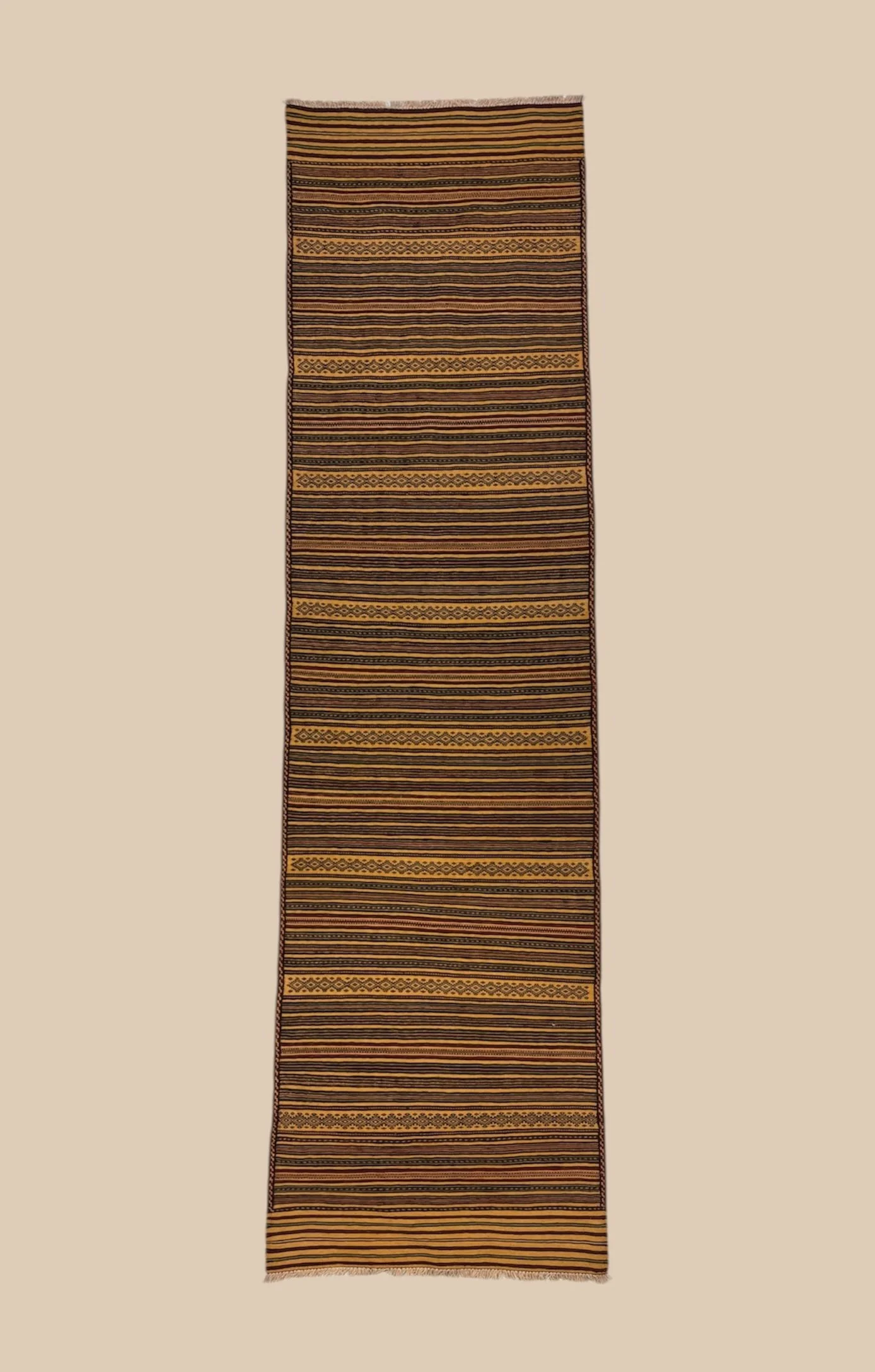 A long, narrow, woven rug with horizontal stripes and geometric patterns in yellow, black, and brown colors.