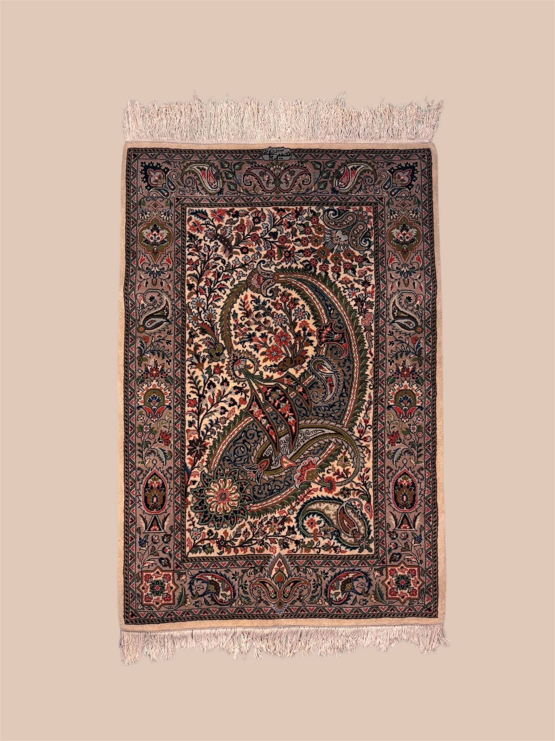 A decorative Persian-style rug with intricate floral and geometric patterns in shades of beige, red, green, and black, with fringes on the top and bottom edges.