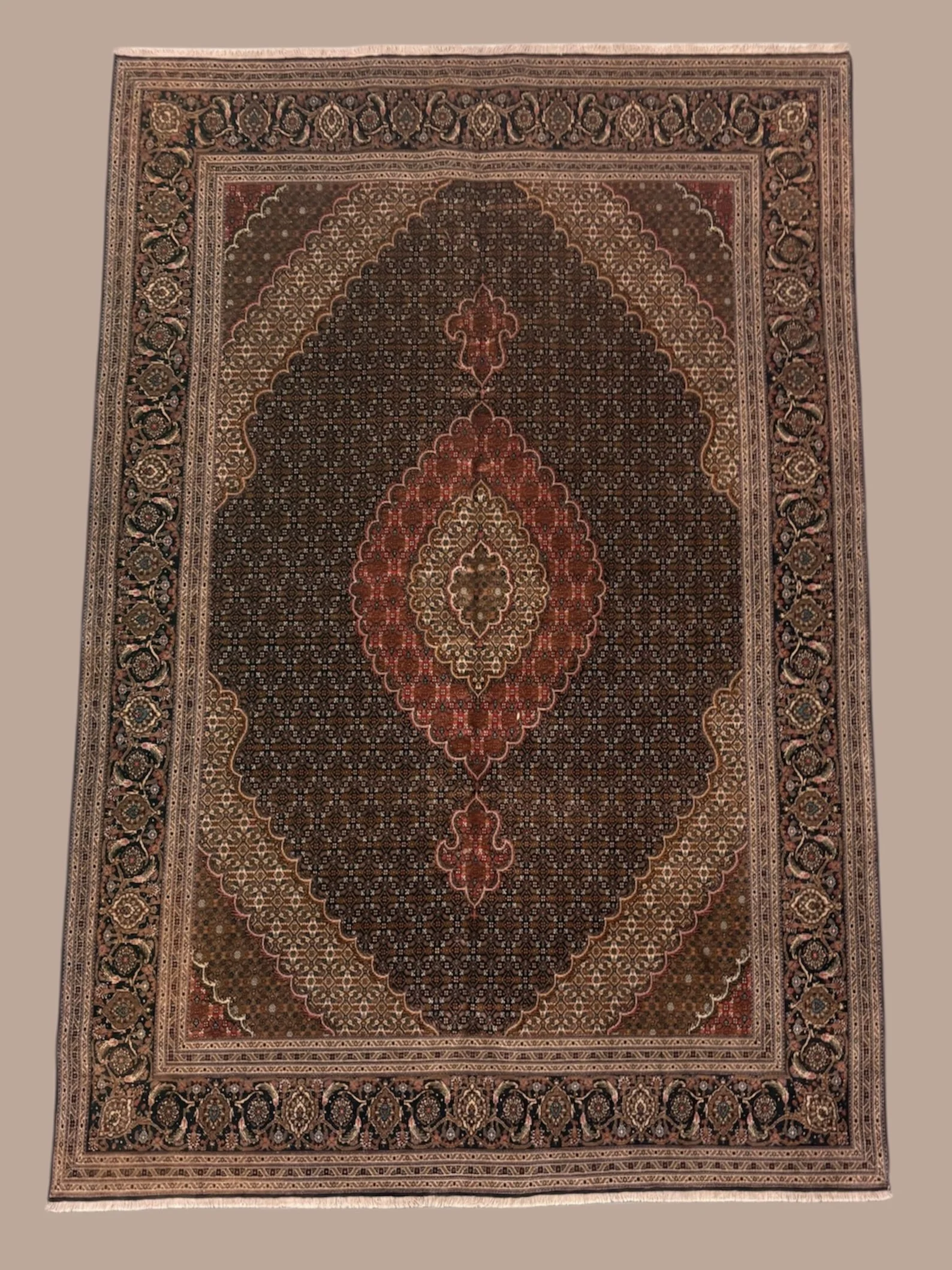 A detailed Persian-style area rug featuring intricate floral and geometric patterns in shades of red, black, beige, and brown.