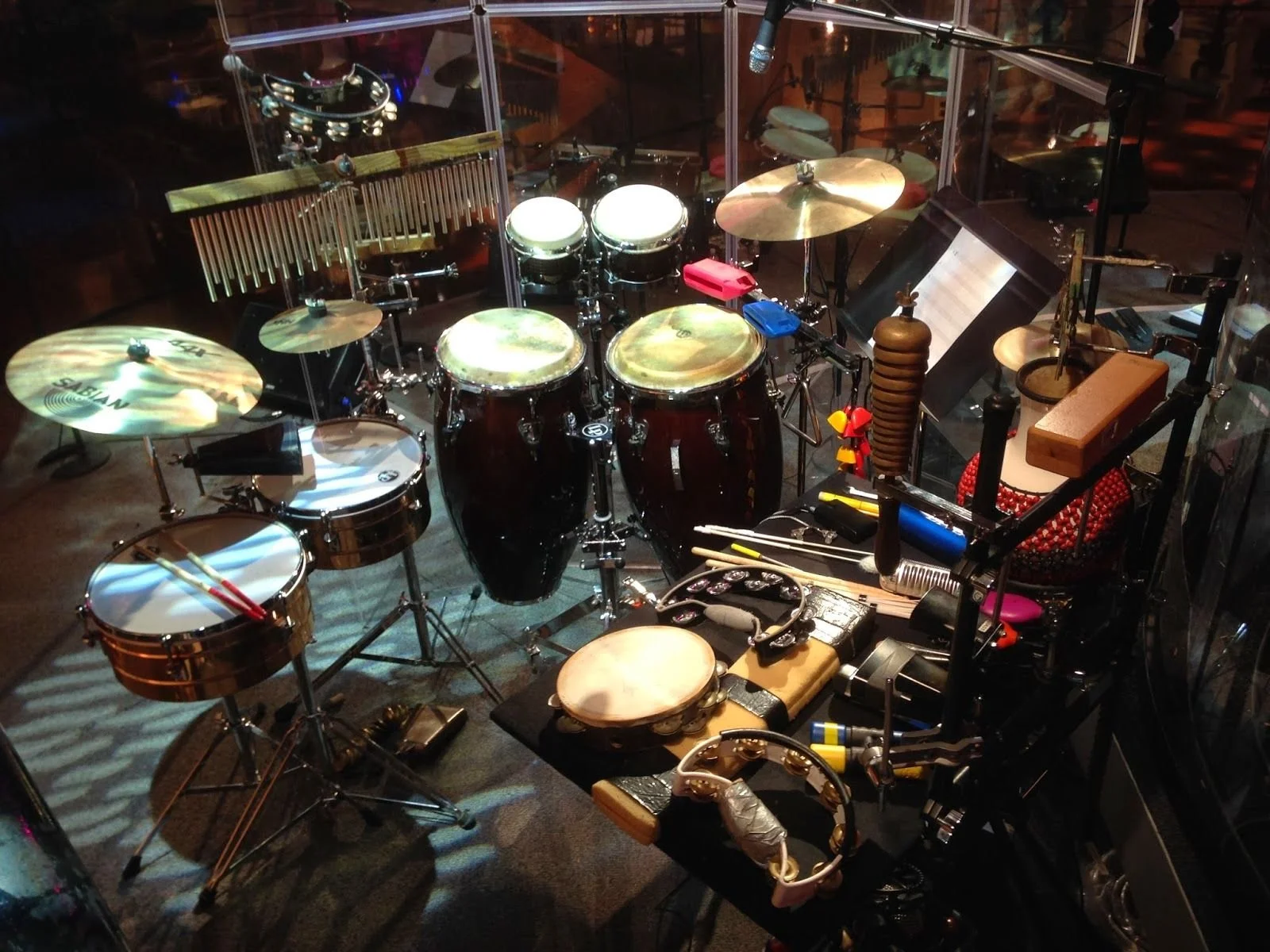 A drum set with various percussion instruments and accessories in a music studio or stage setting.