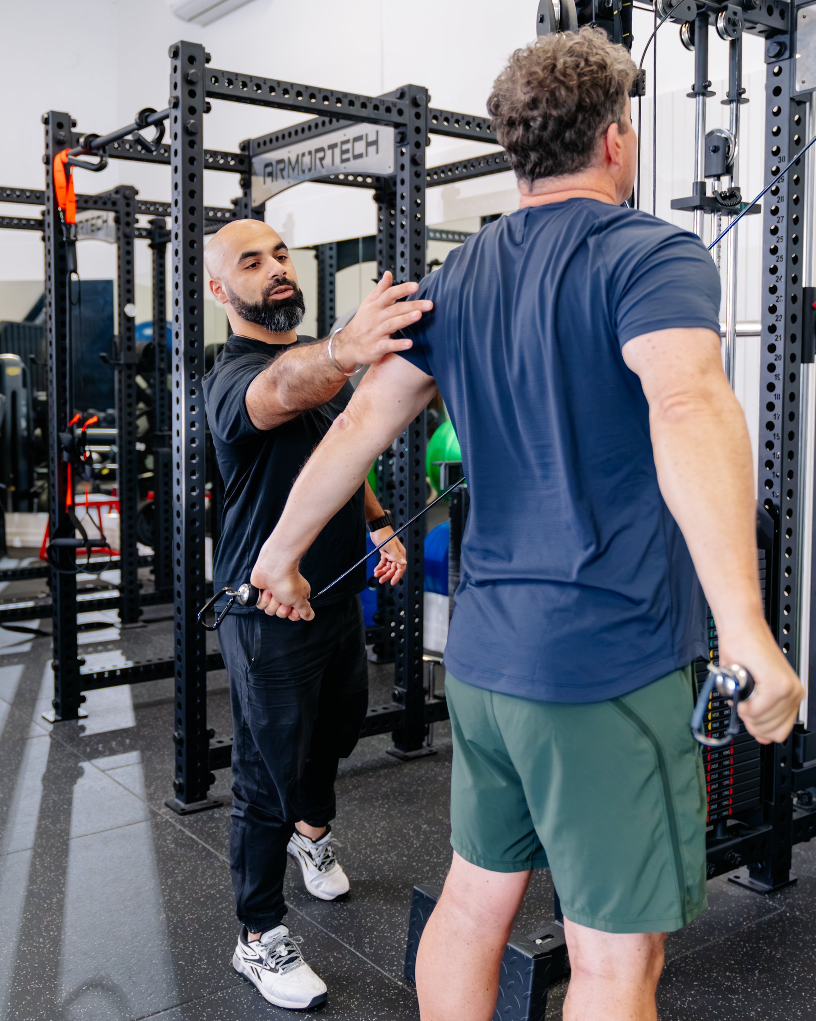 A Man doing a standing cable row in the Precision Fitness gym in Albany, Auckland