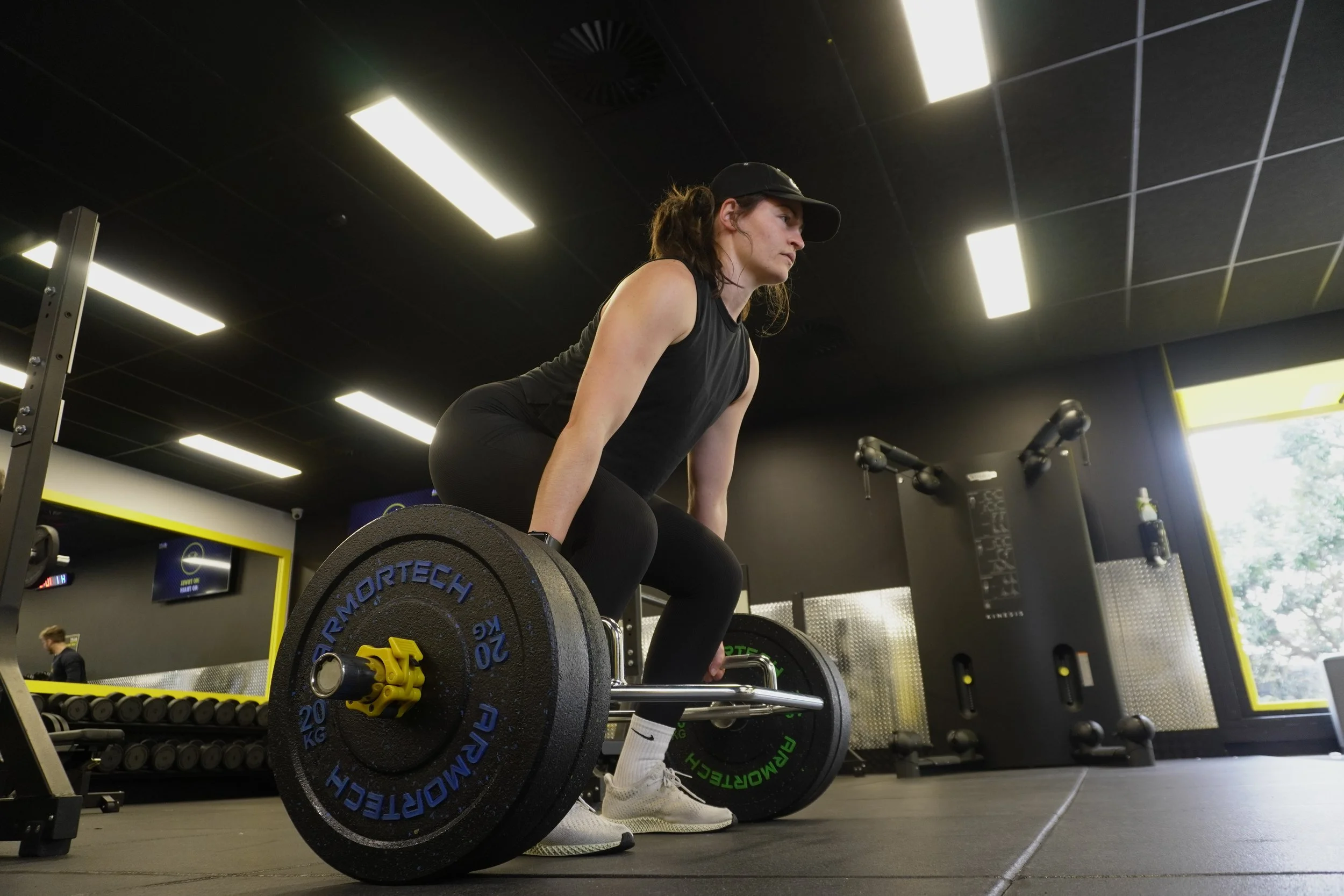 A lady performing a deadlift in the Precision Fitness gym