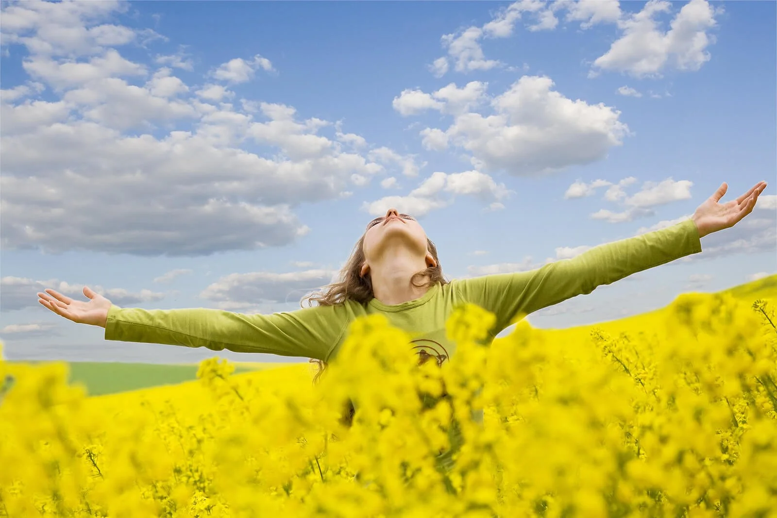 A girl spreads her arms in a sunny flower field, capturing the freedom that I-CBT for OCD in Provo, UT makes possible. I-CBT in Provo, UT leads to genuine relief from obsessive doubt.