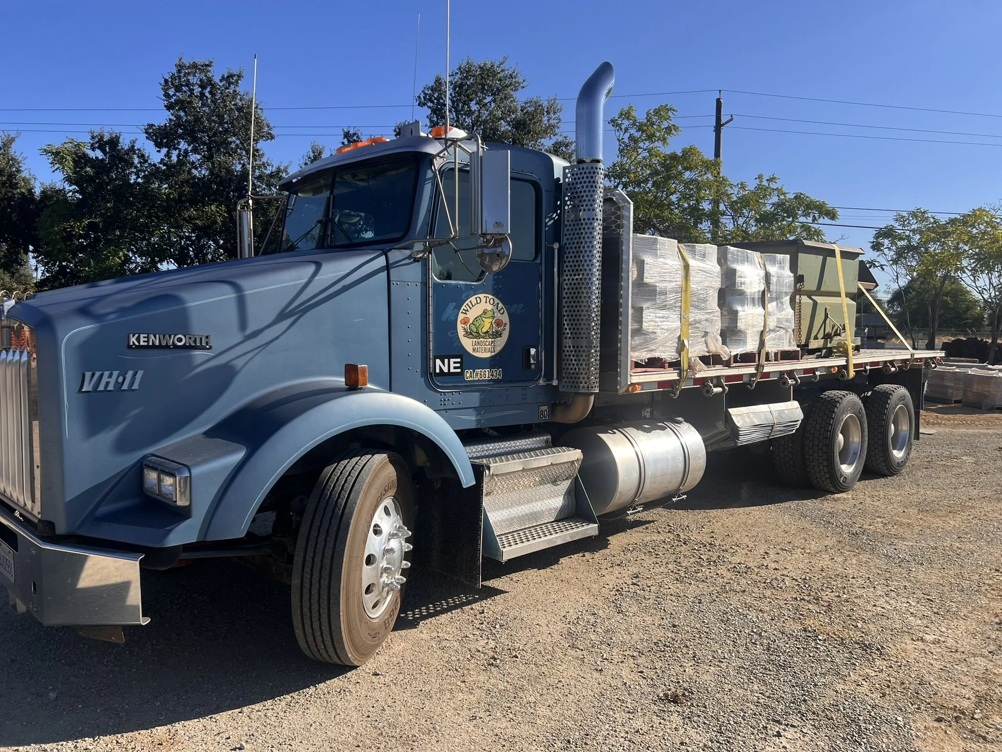 Flatbed delivery truck with piggyback forklift delivering construction materials from Wild Toad Landscape Materials in Anderson, CA to Anderson and Redding.