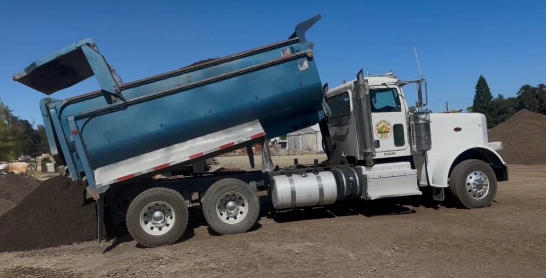 Dump truck unloading soil for a landscaping project supplied by Wild Toad Landscape Materials serving Anderson, Redding, Cottonwood, and nearby areas.