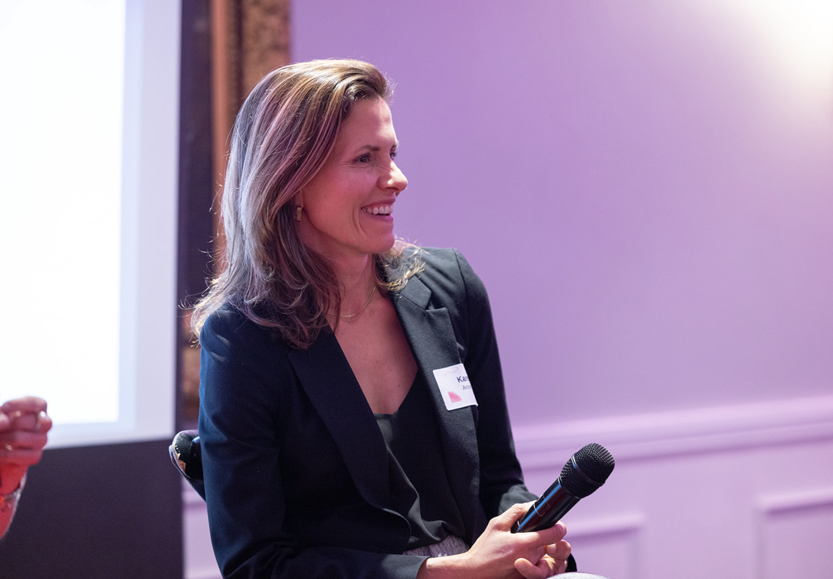 Person speaking at an event as part of a panel.