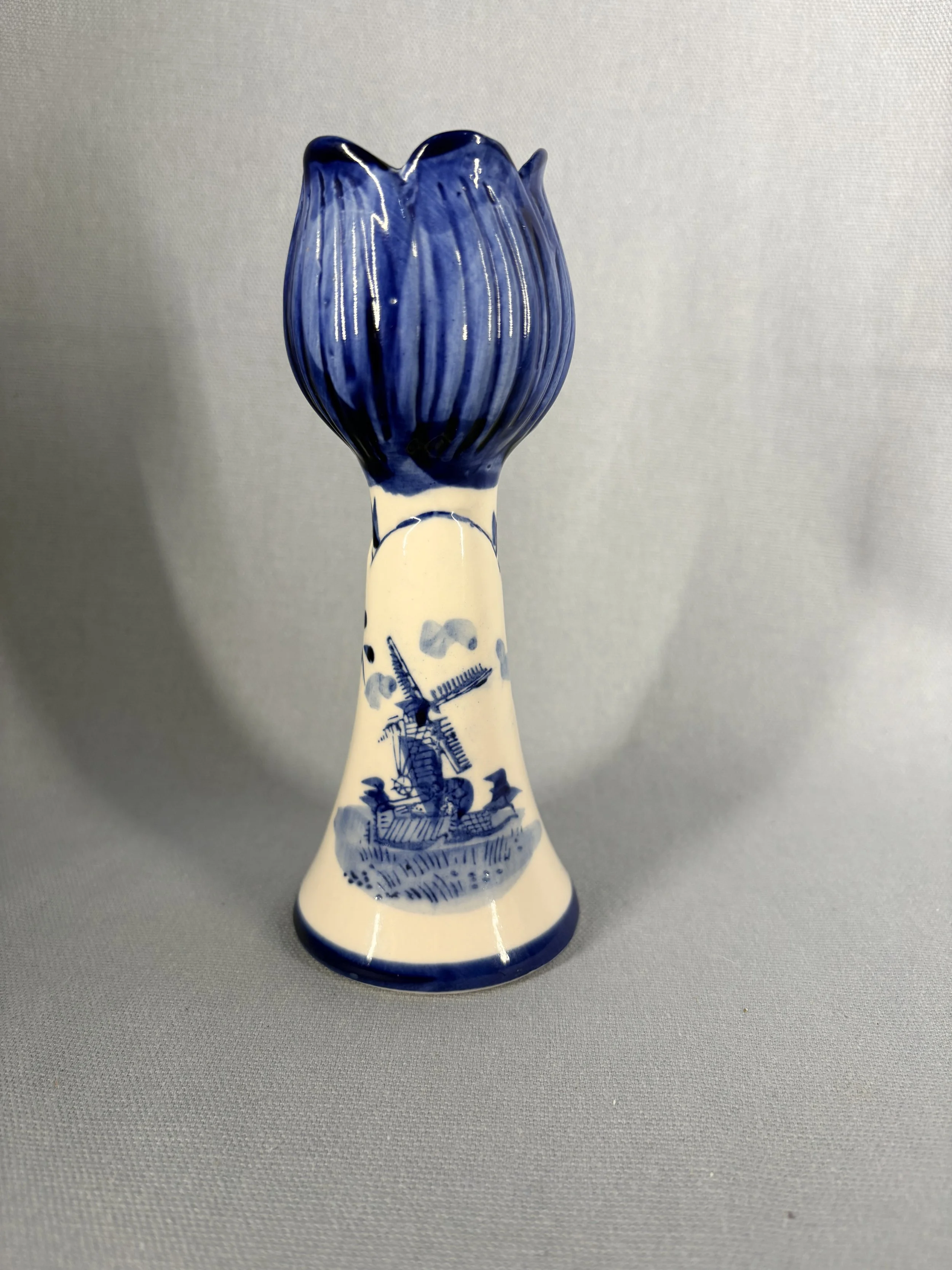 A charming hand-painted Delft blue bud vase in the form of a stylised tulip, decorated in cobalt blue on a creamy white ground.