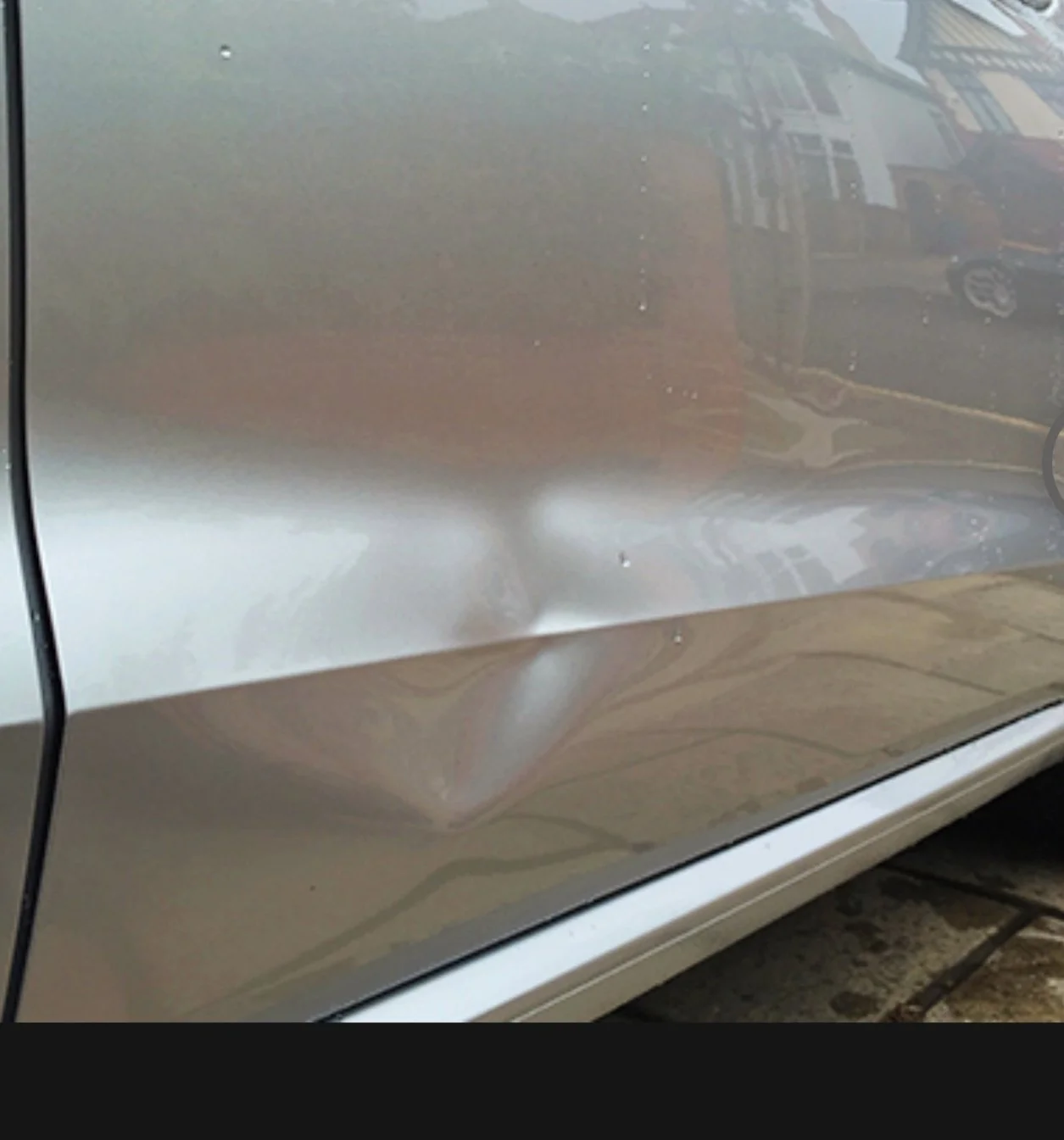 Auto mit Beule an der Fahrerseite, sichtbar auf der Seite des Fahrzeugs