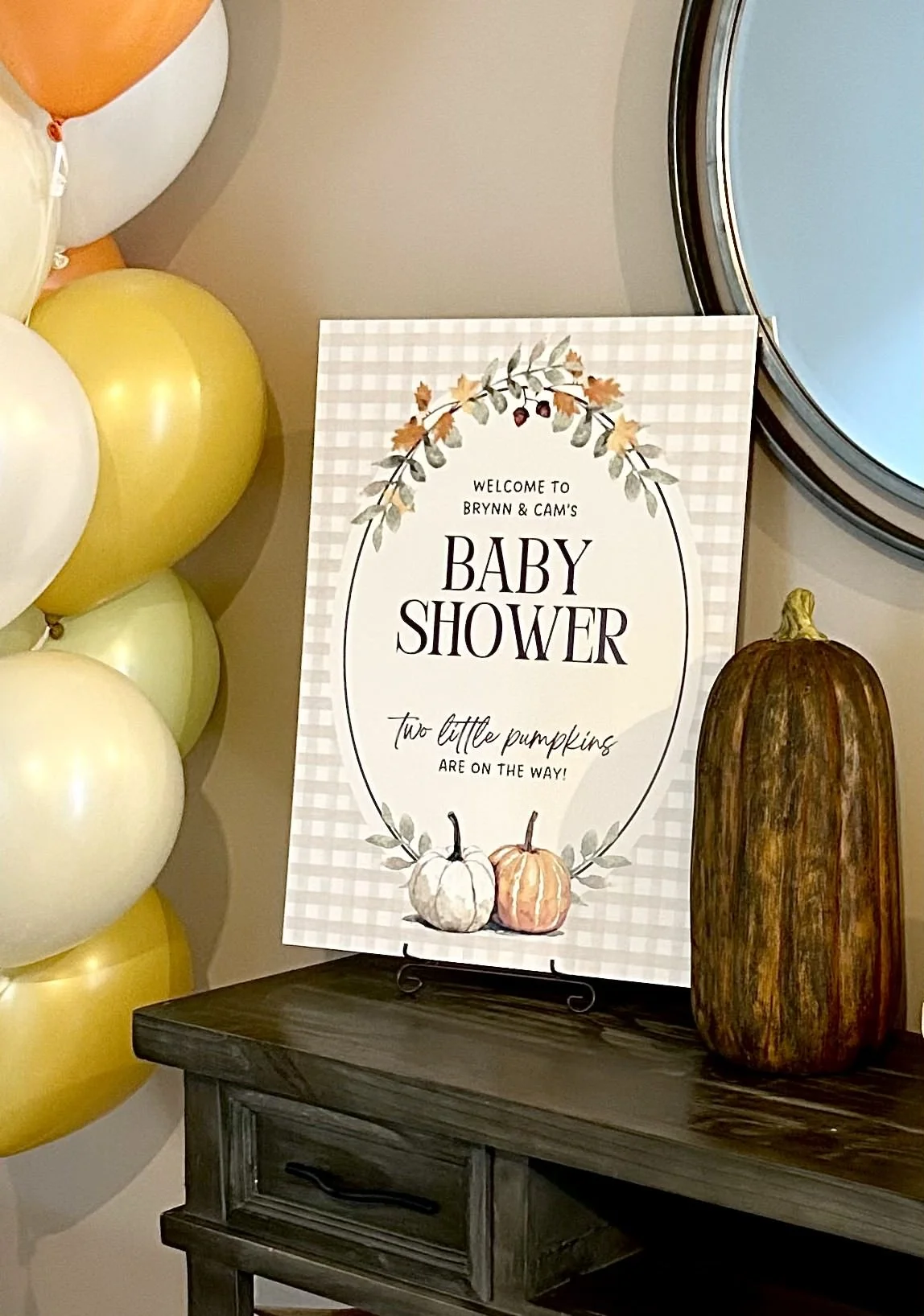 Welcome sign poster for a baby shower featuring a tan gingham print and pumpkins
