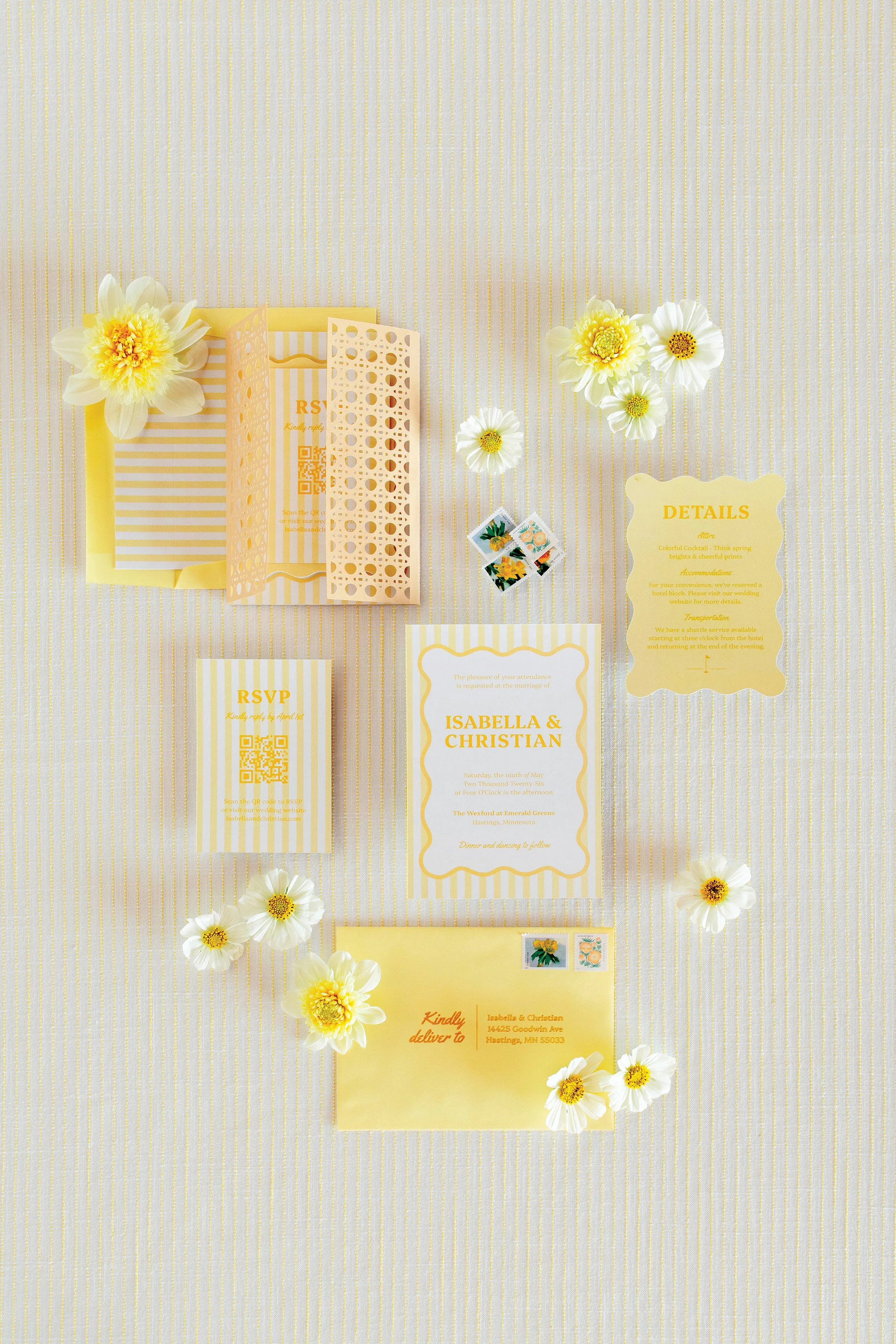 Yellow invitation suite flat lay with flowers placed around it