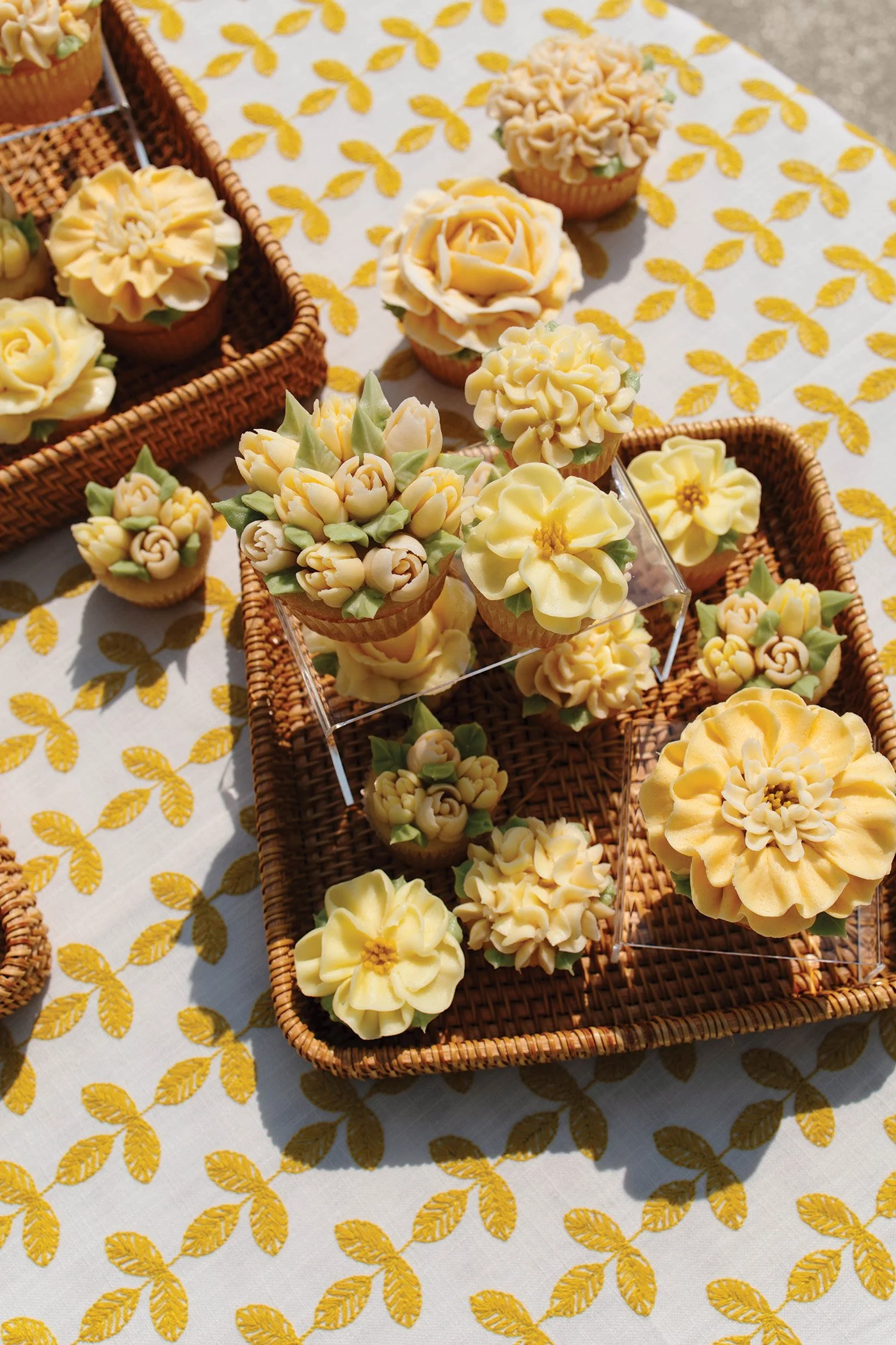 A spread of yellow frosted floral cupcakes 